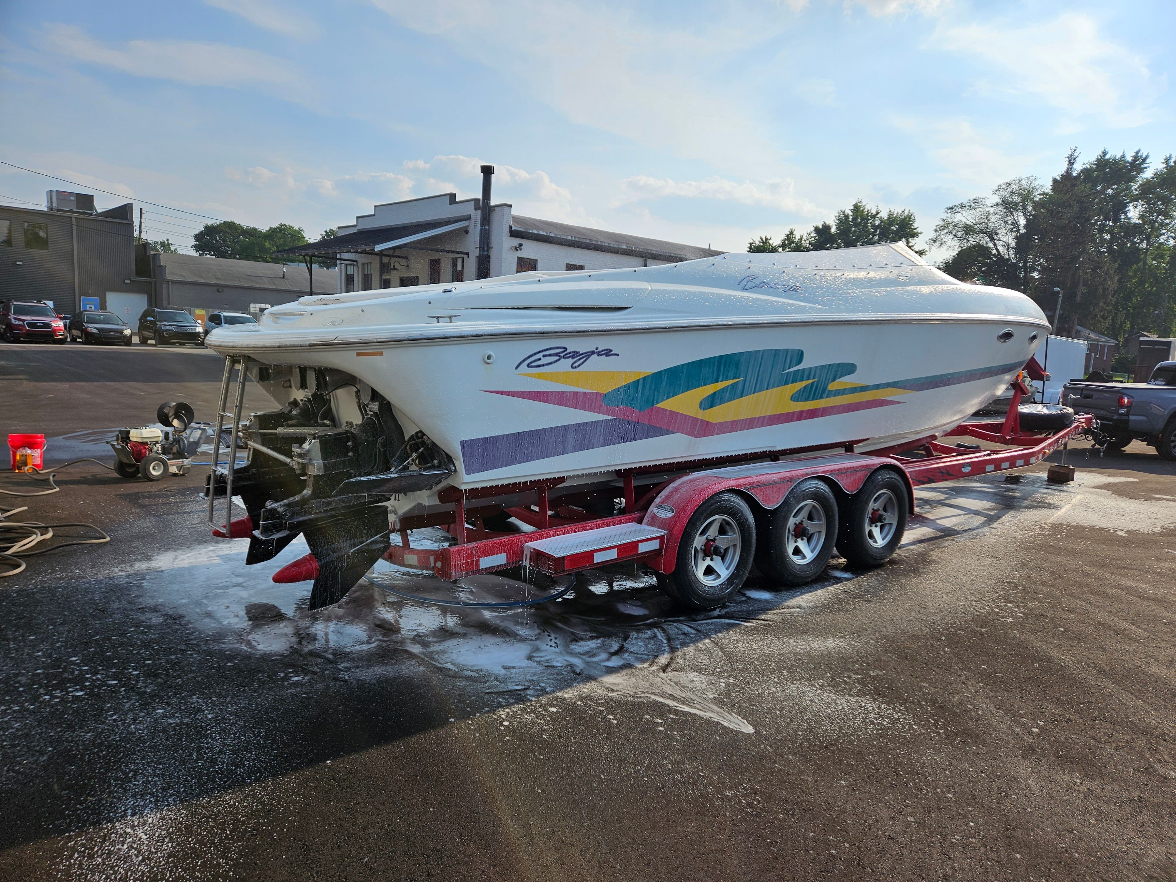 A 1996 Baja 302 Boss on a trailer, being washed. Colorful graphics on the side.