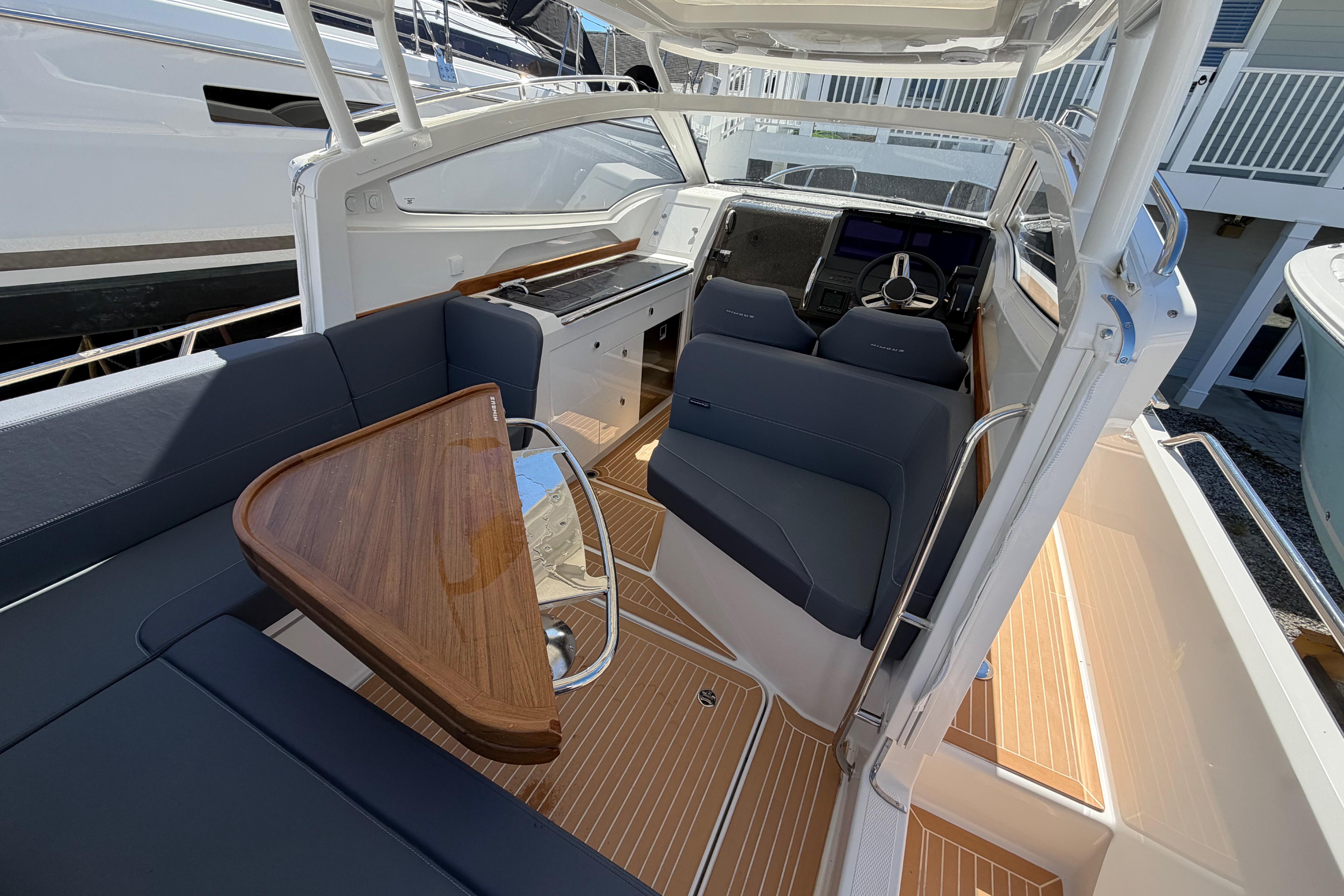 Interior of 2025 Nimbus Weekender 9 boat with sleek seating and wooden table.