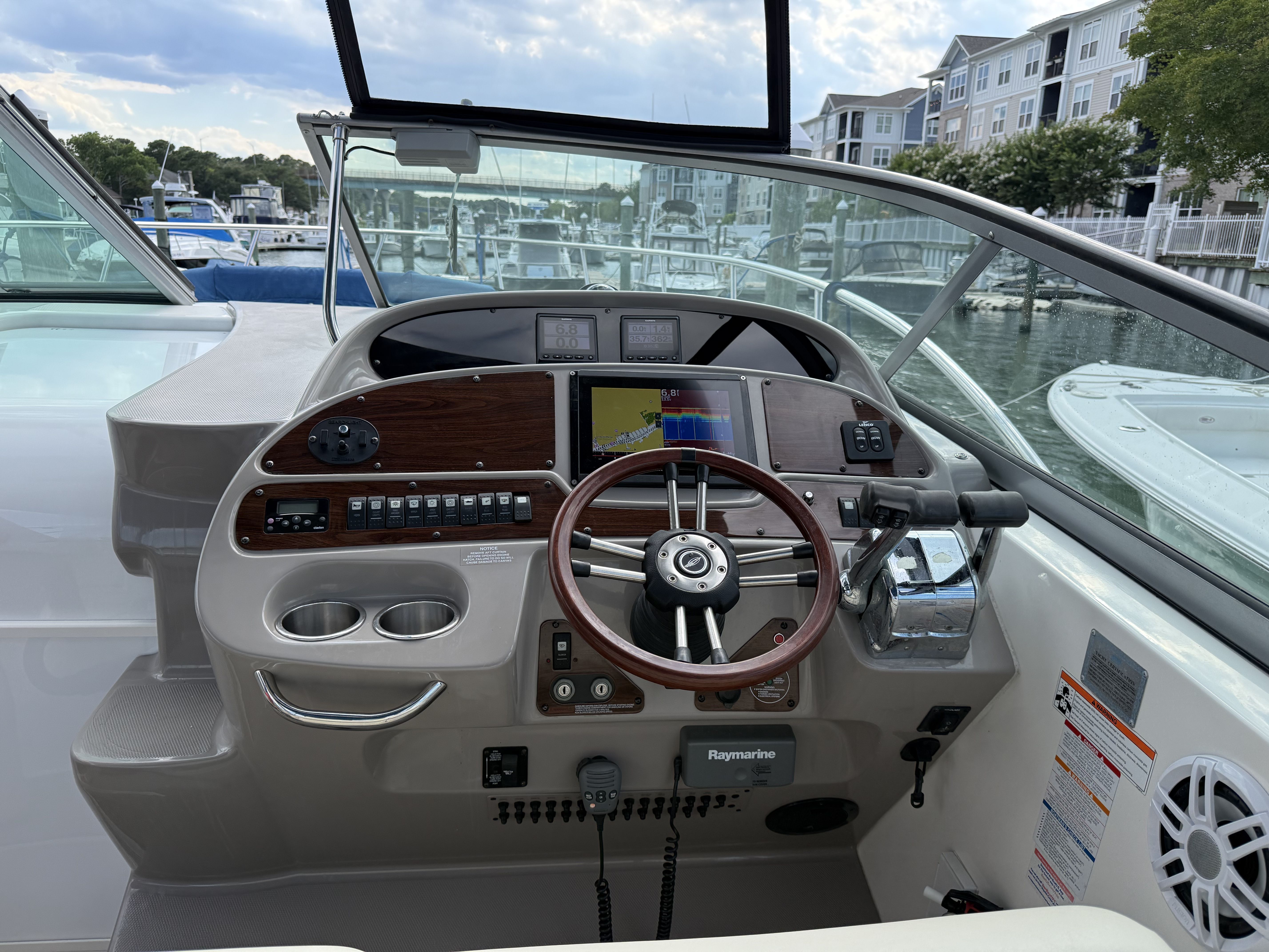 The cockpit of a 2008 Chaparral Signature 330 with a sleek wood steering wheel and modern instruments.