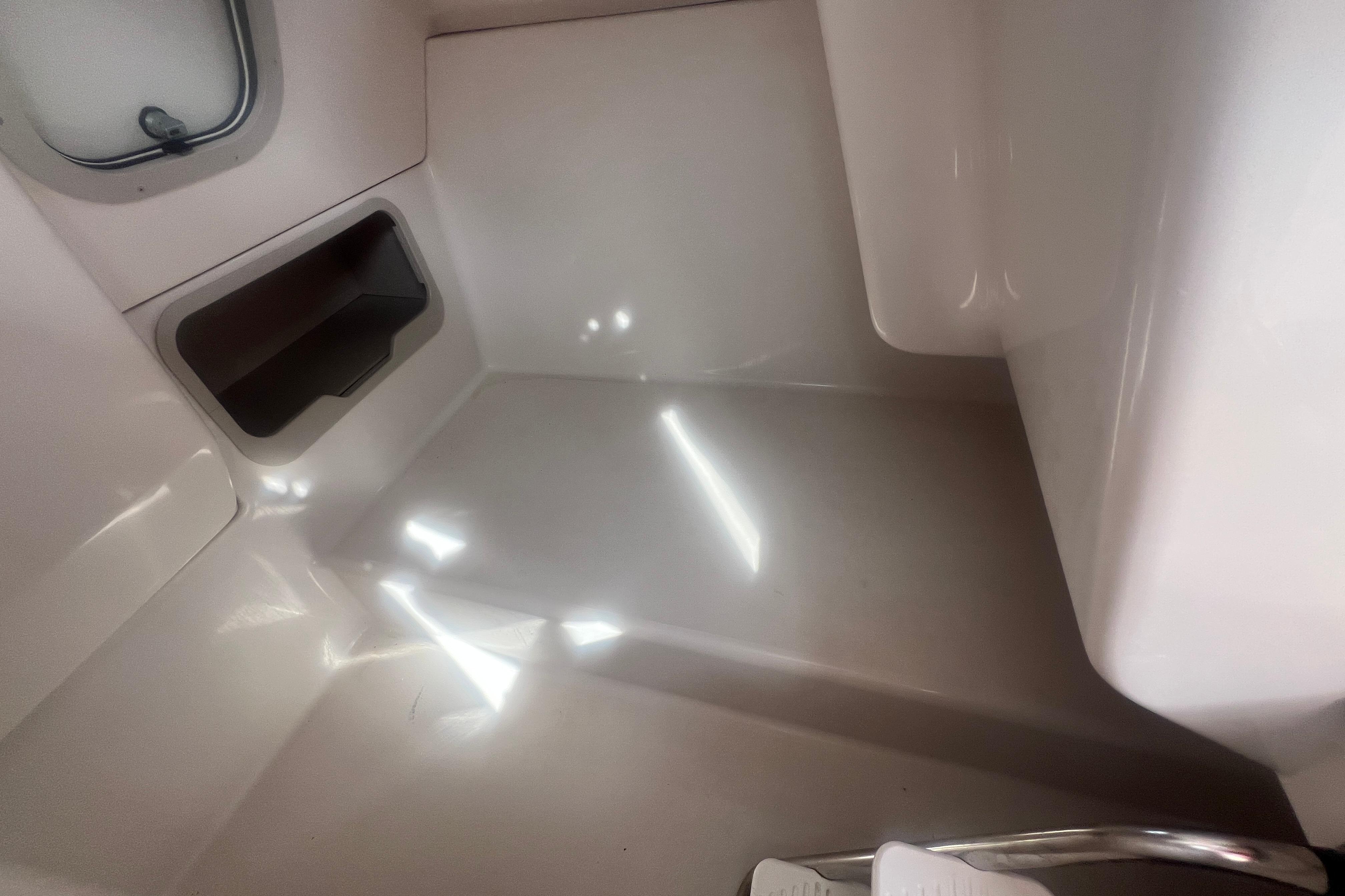 Interior view of a 2002 Hurricane SunDeck 260 OB boat, featuring sleek white surfaces.