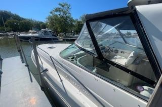 2000 Rinker Fiesta Vee 310 boat docked at marina under clear blue sky.