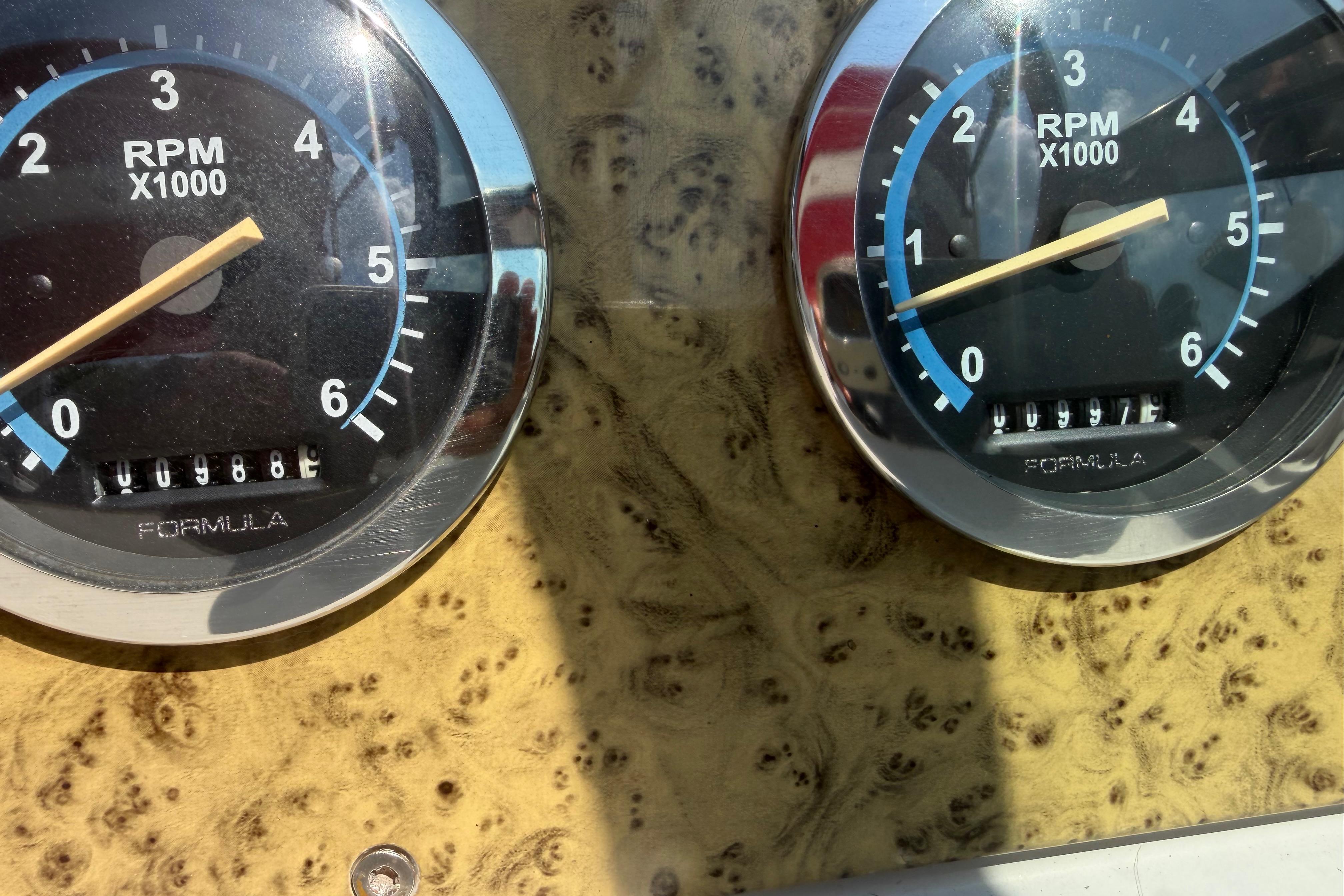 Close-up of RPM gauges on a 2006 Formula 330 Sun Sport boat dashboard.