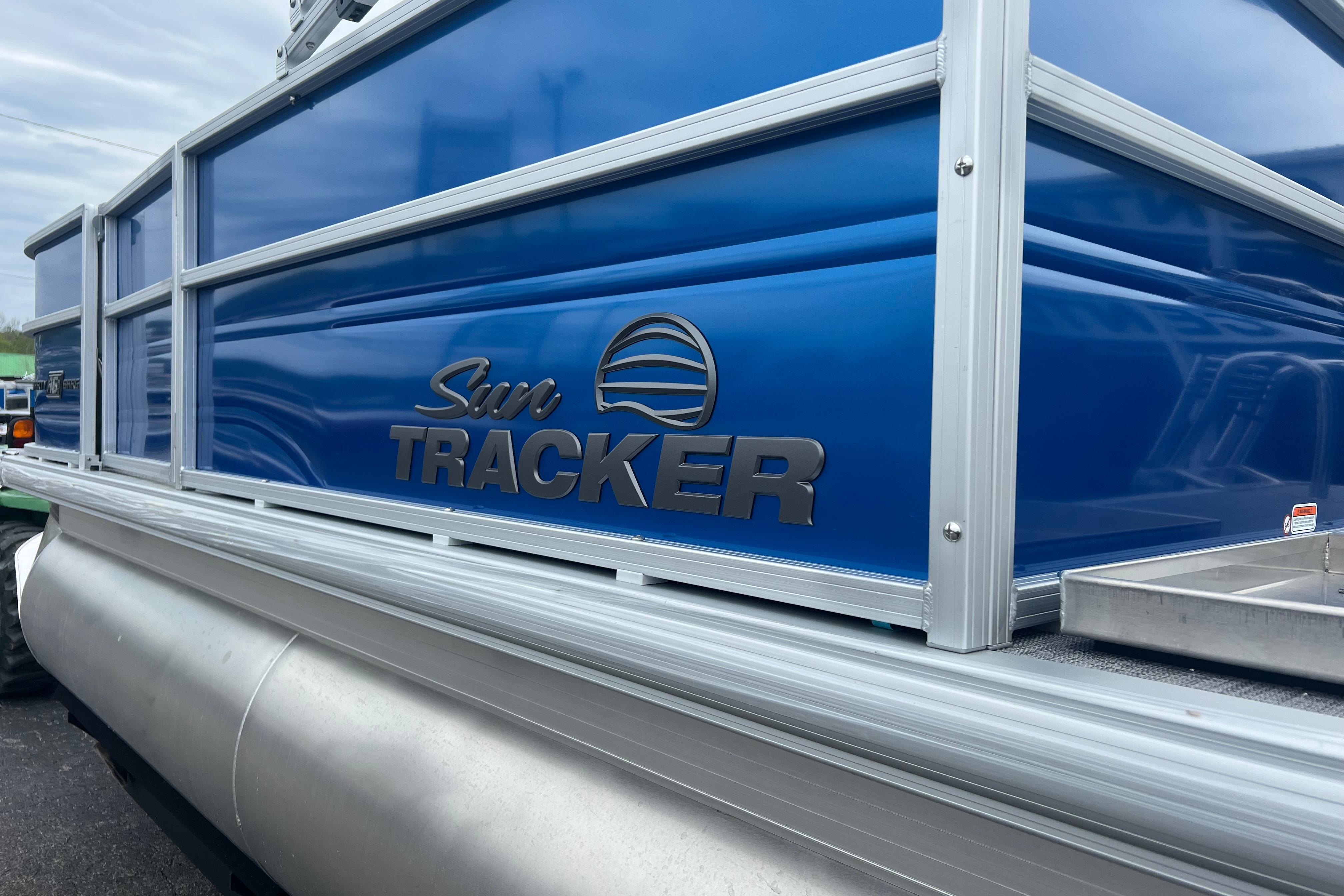 2026 Sun Tracker Party Barge 16 DLX pontoon boat with blue exterior and logo.