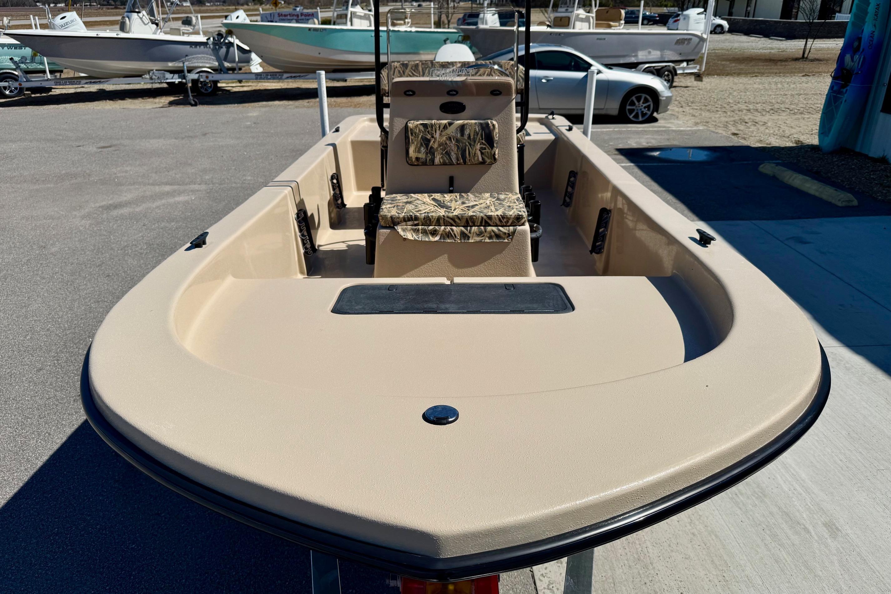 2026 Carolina Skiff E18 JVX CC boat, beige interior, parked outdoors.