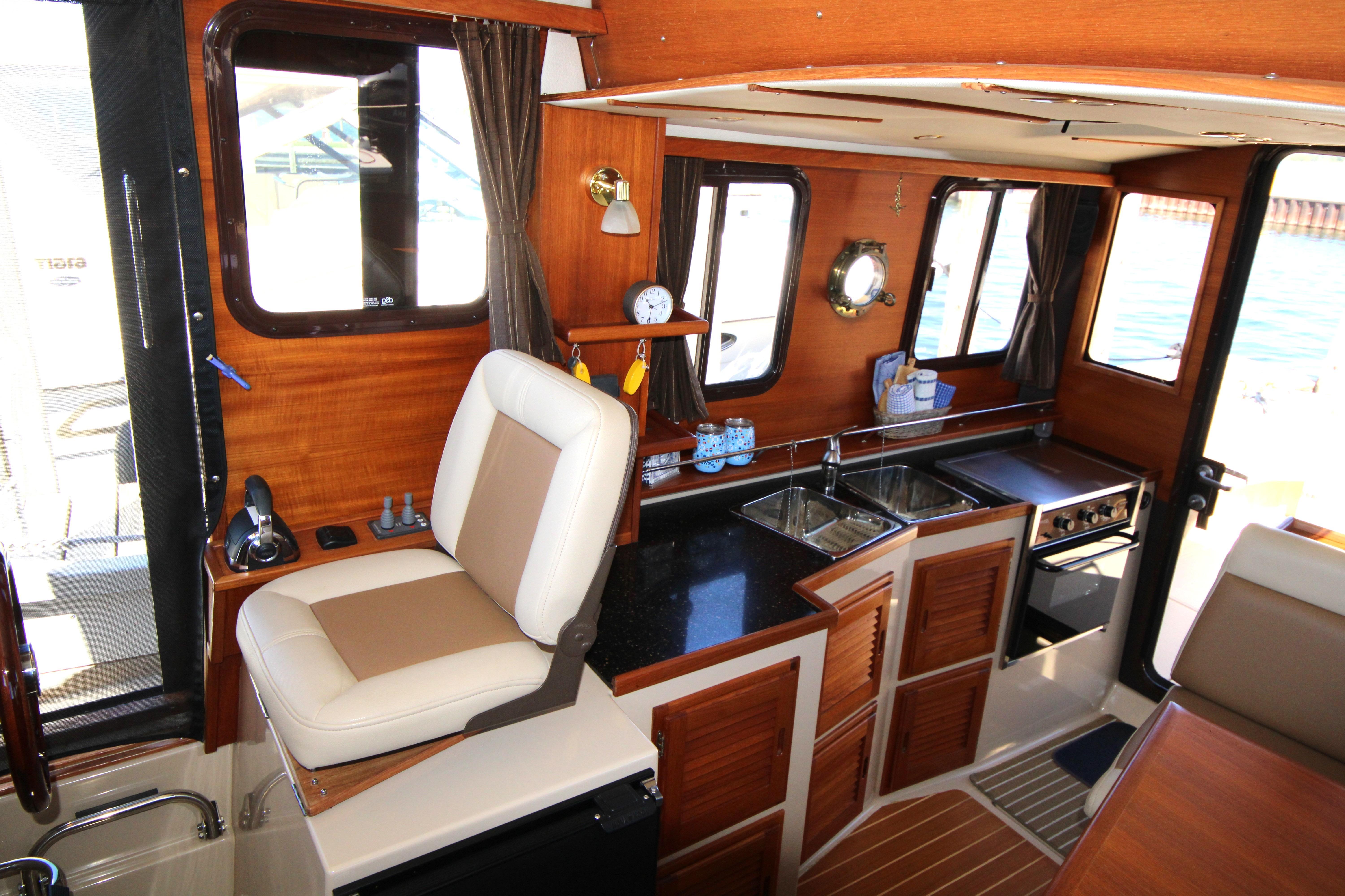 Interior of 2013 Ranger Tugs R-31 CB, featuring a compact kitchen and helm station.