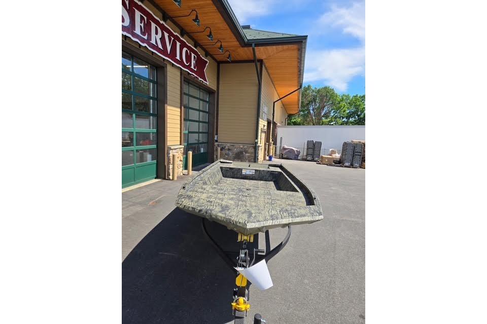 2026 Tracker Grizzly 1860 Utility boat parked outside a service building.