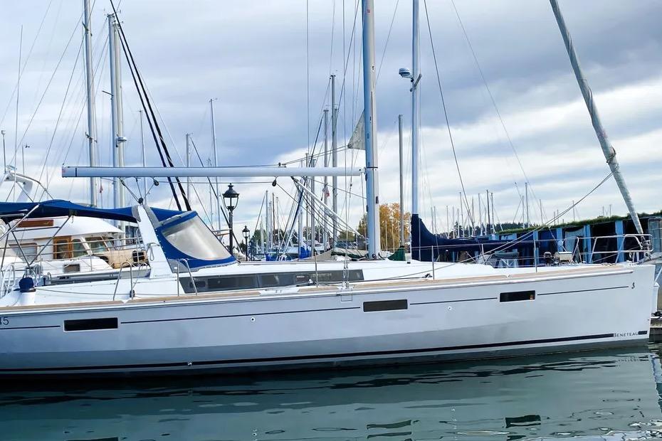 2018 Beneteau Oceanis 45 sailboat docked in a marina under cloudy skies.