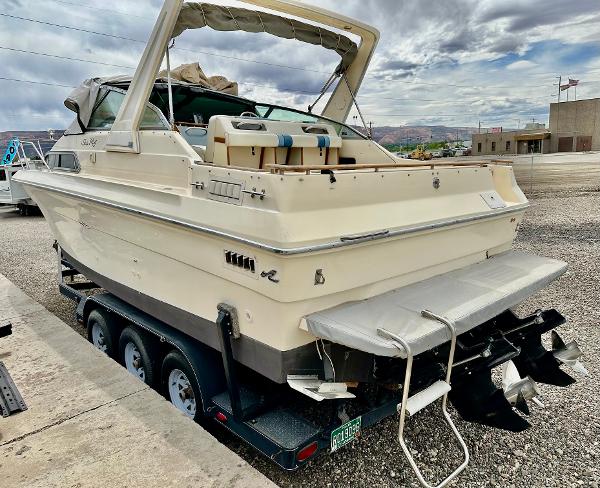 1987 Sea Ray 270 Sundancer boat on trailer, rear view, parked outdoors.