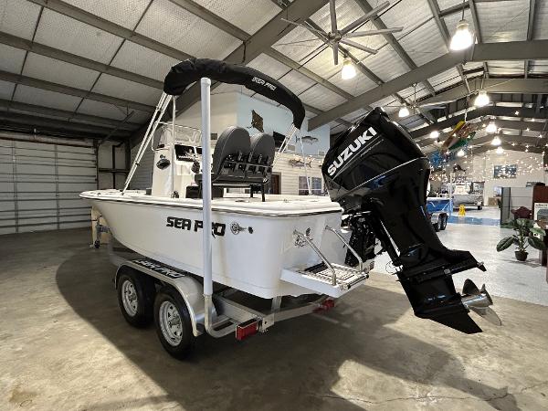 2025 Sea Pro 210 Bay boat with Suzuki engine in a showroom.