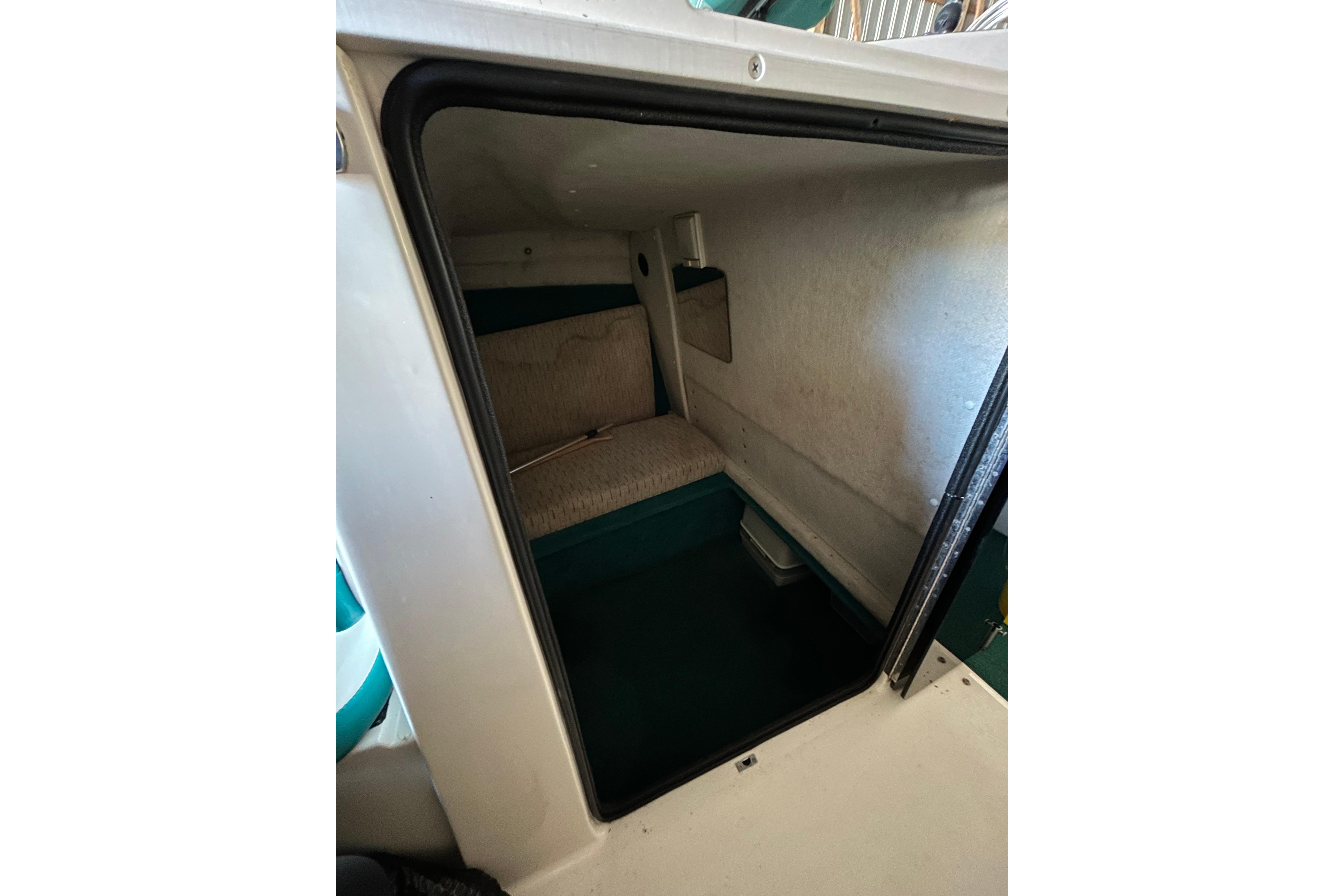 Interior cabin of 1991 Wellcraft 232 Eclipse boat, featuring compact sleeping area.