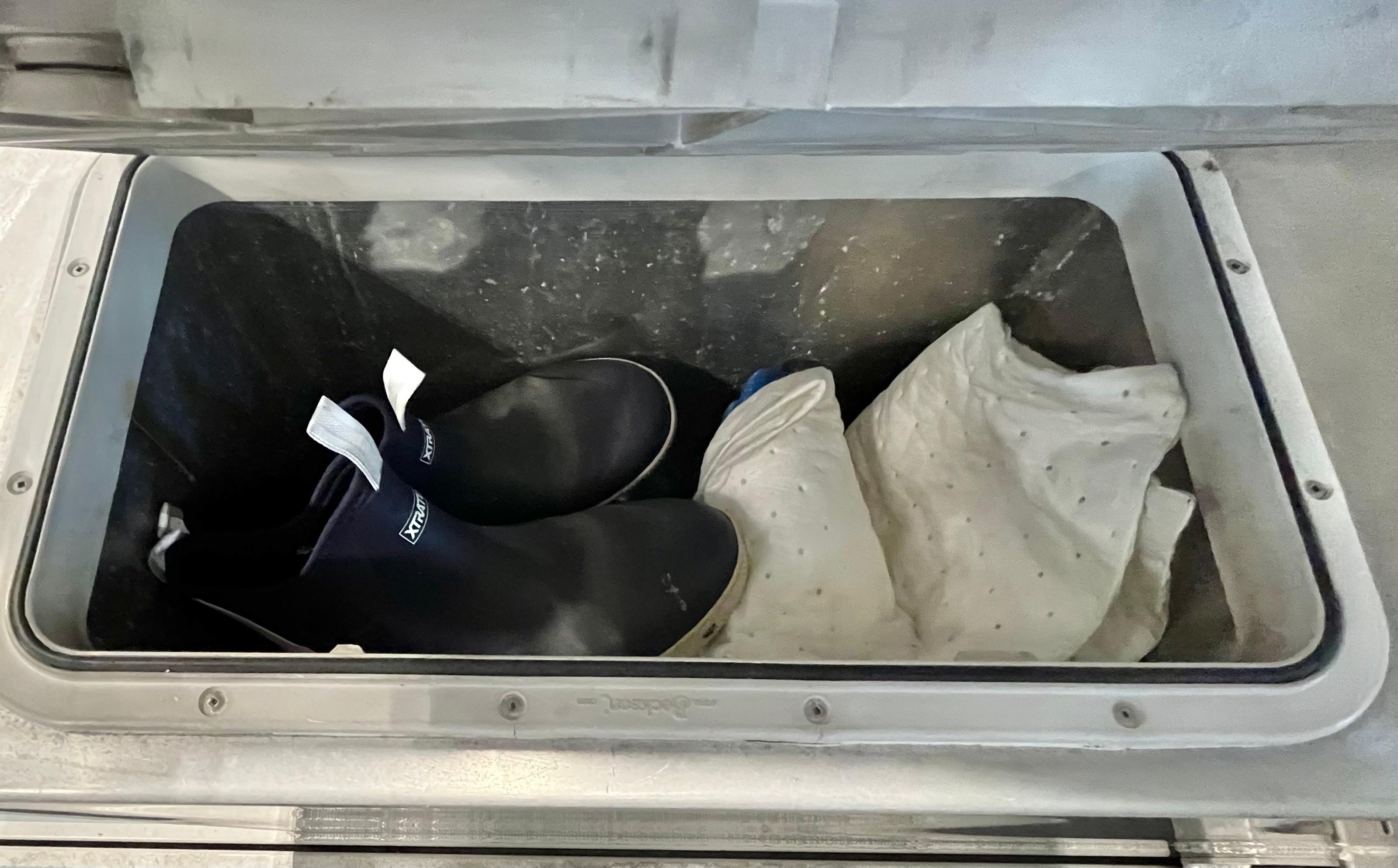 Storage compartment on 2007 Coastal Craft 36 Cruiser with boots and fabric inside.