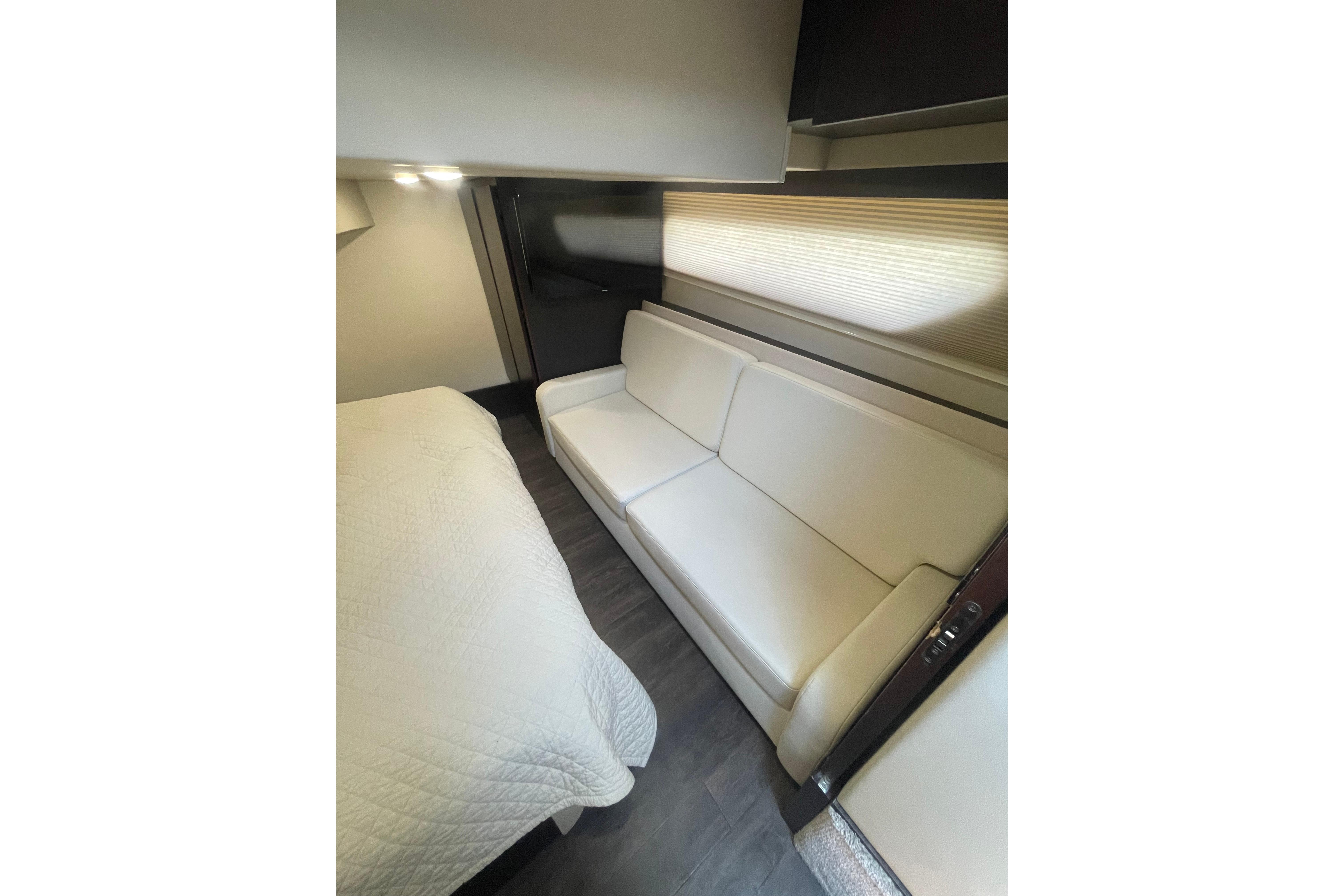 Interior of 2020 Regal 42 Grande Coupe with white sofa and bed.