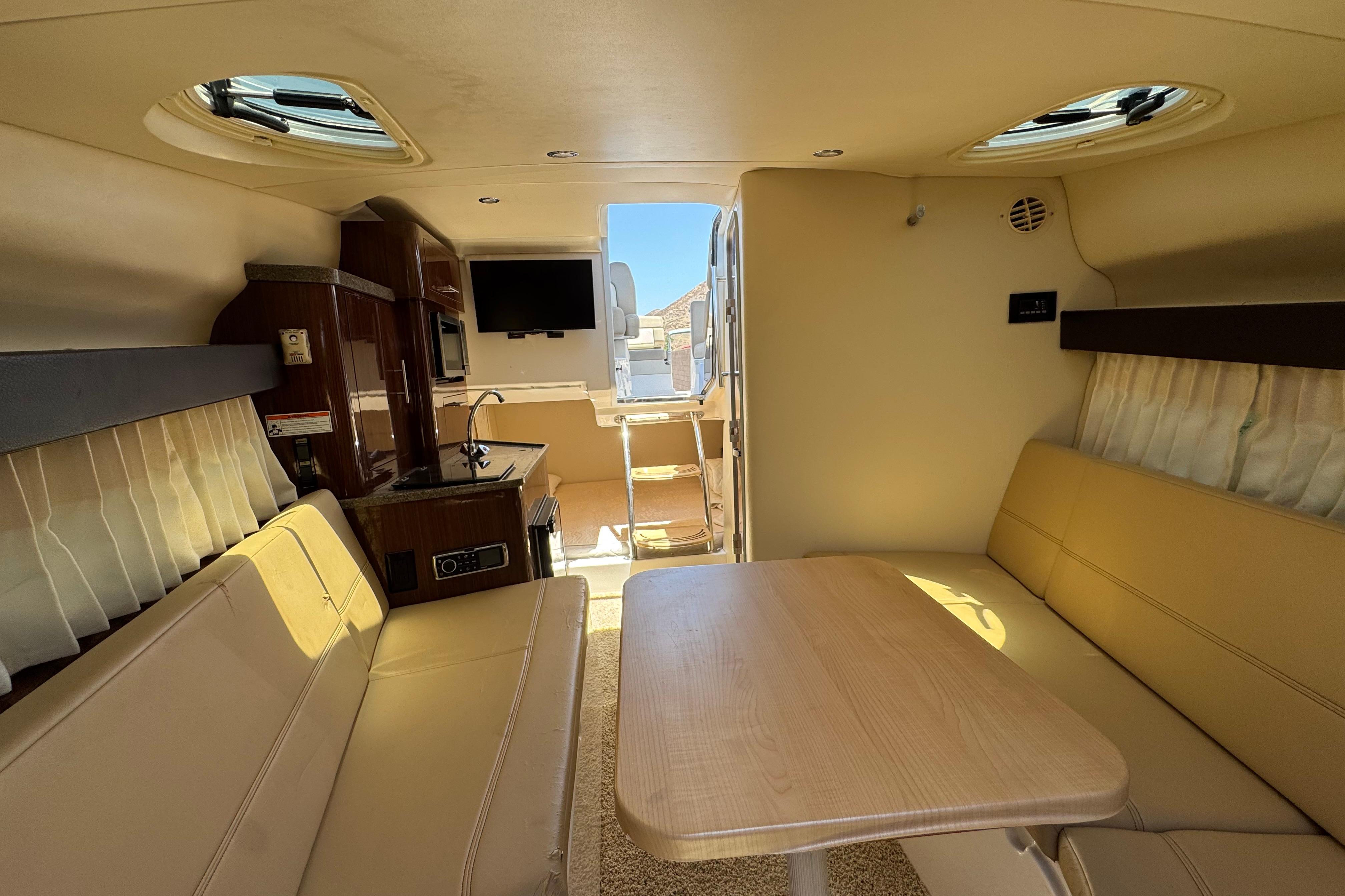 Interior of a 2013 Regal 28 Express boat with seating, table, and kitchenette.