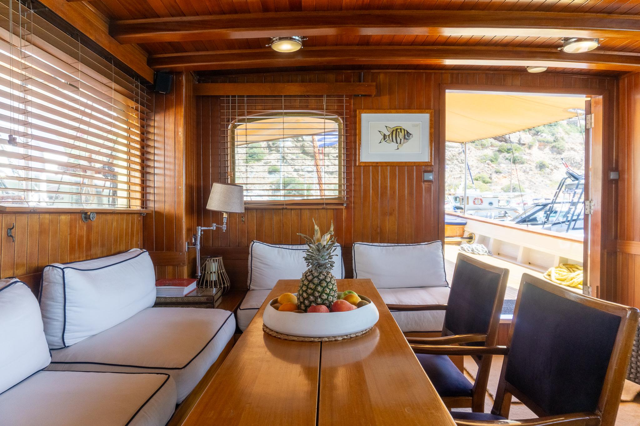 Luxurious 1969 Psarros Shipyard yacht interior with wooden decor and comfortable seating.