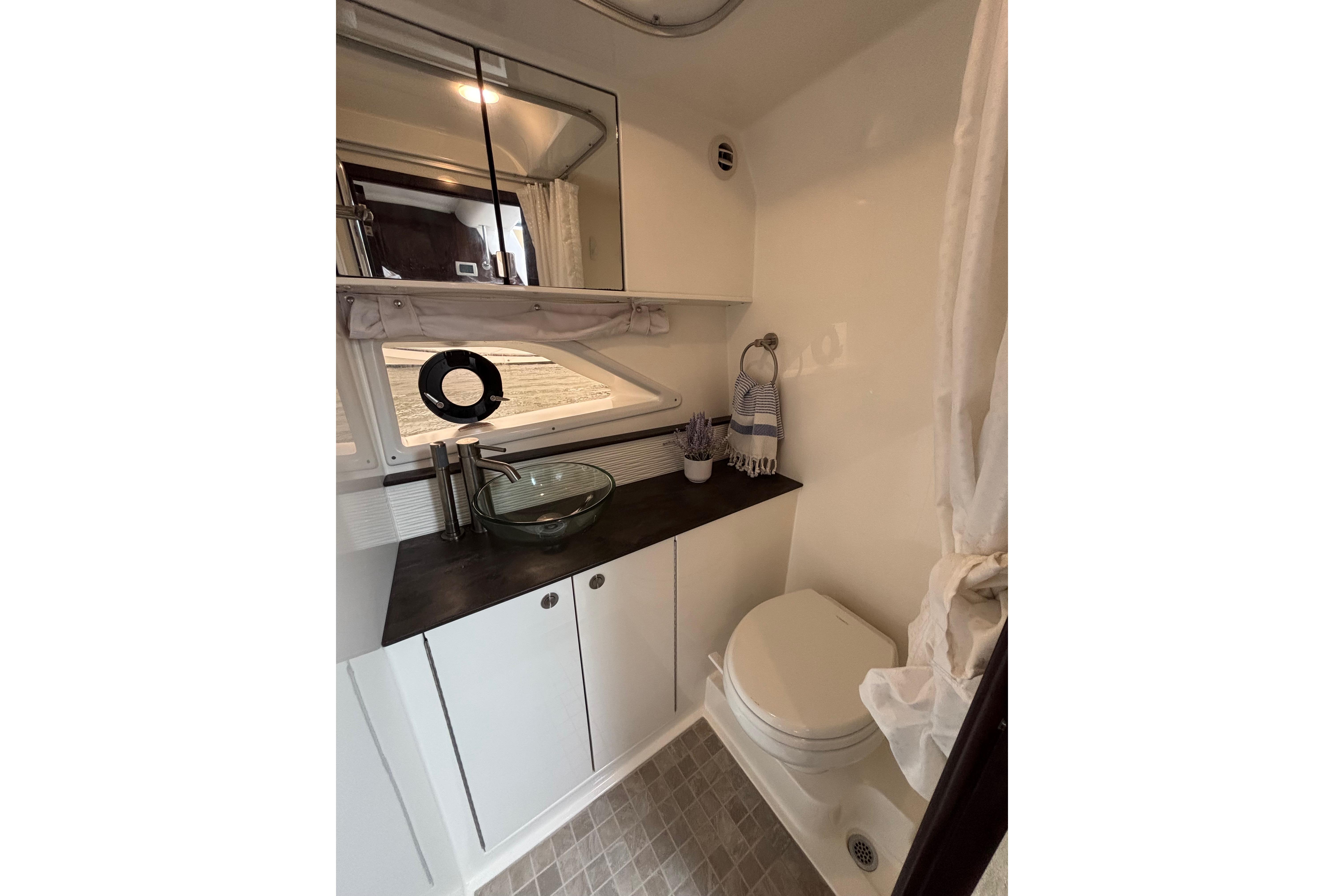 2021 Sea Ray Sundancer 320 Outboard bathroom with modern sink and compact design.