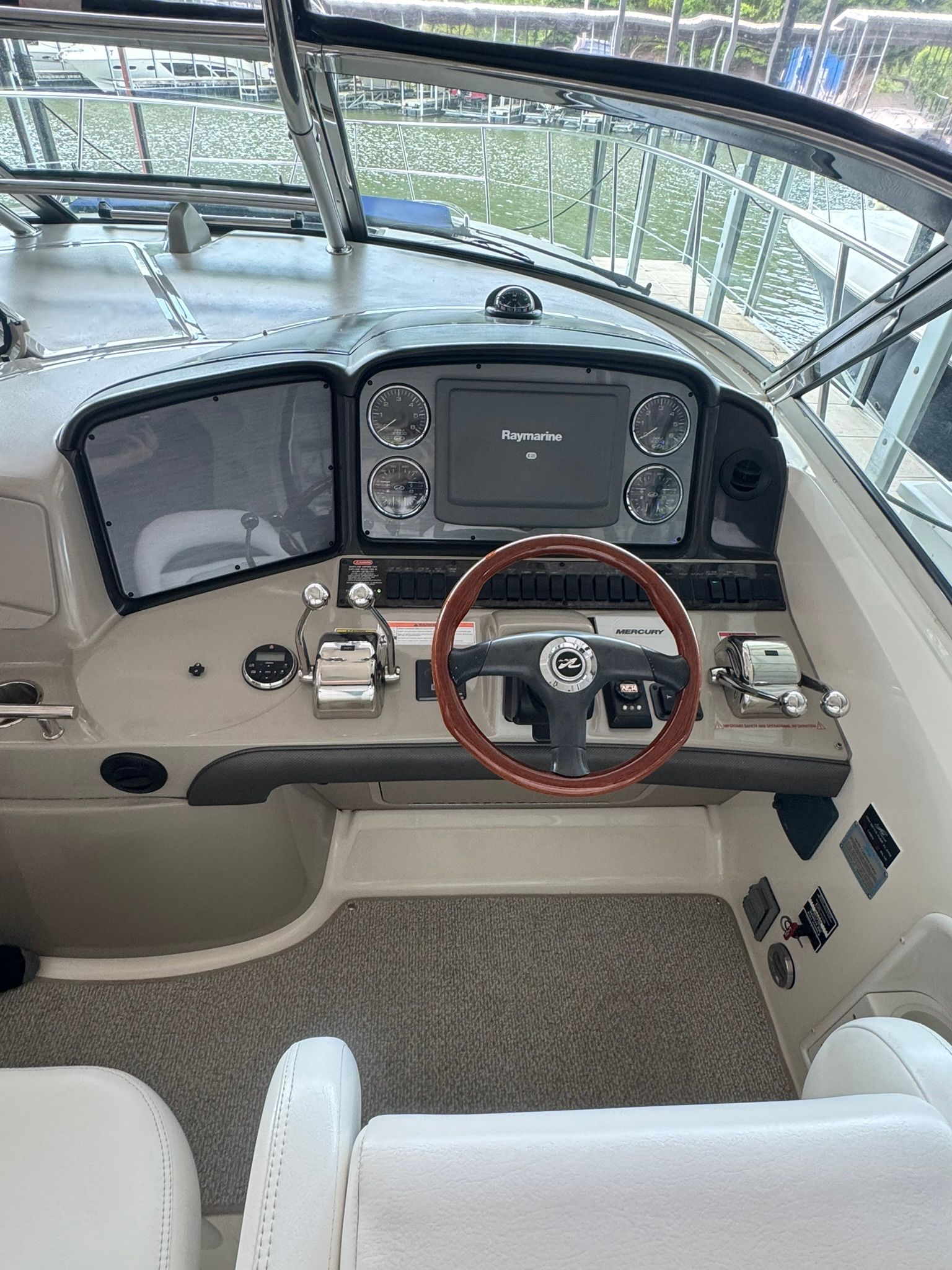 The image shows the helm of a 2007 Sea Ray 40 Sundancer with a wooden steering wheel.