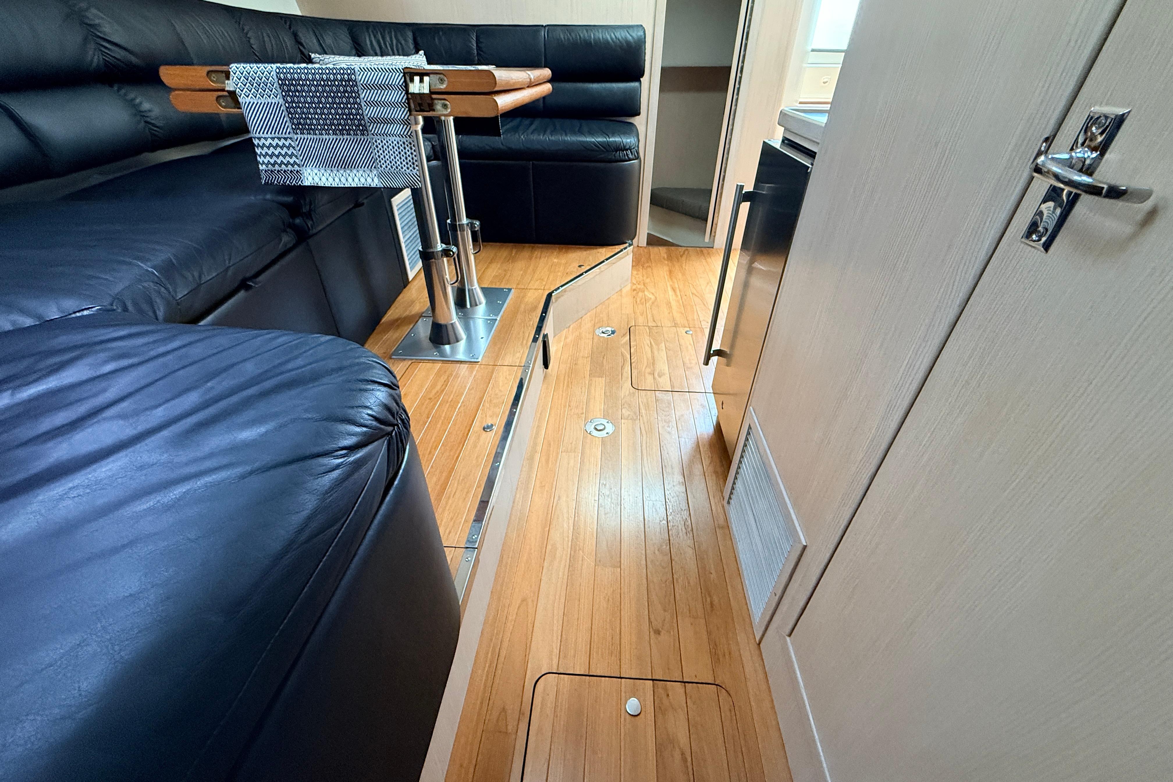 Interior of a 1995 Tiara Yachts 4000 Express with sleek wood flooring and black seating.