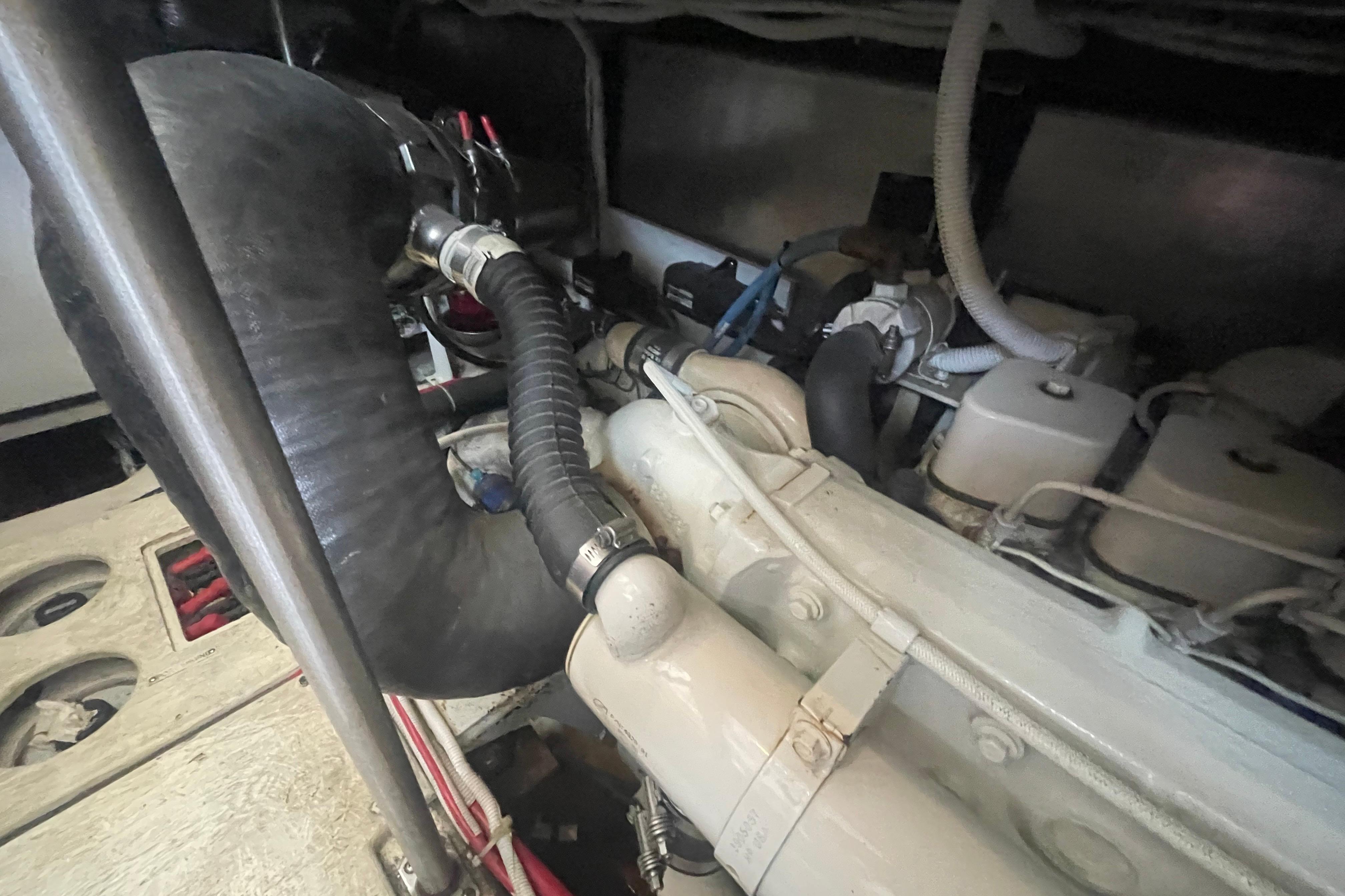 Engine compartment of a 2002 Carver 410 Sport Sedan, showcasing hoses and components.