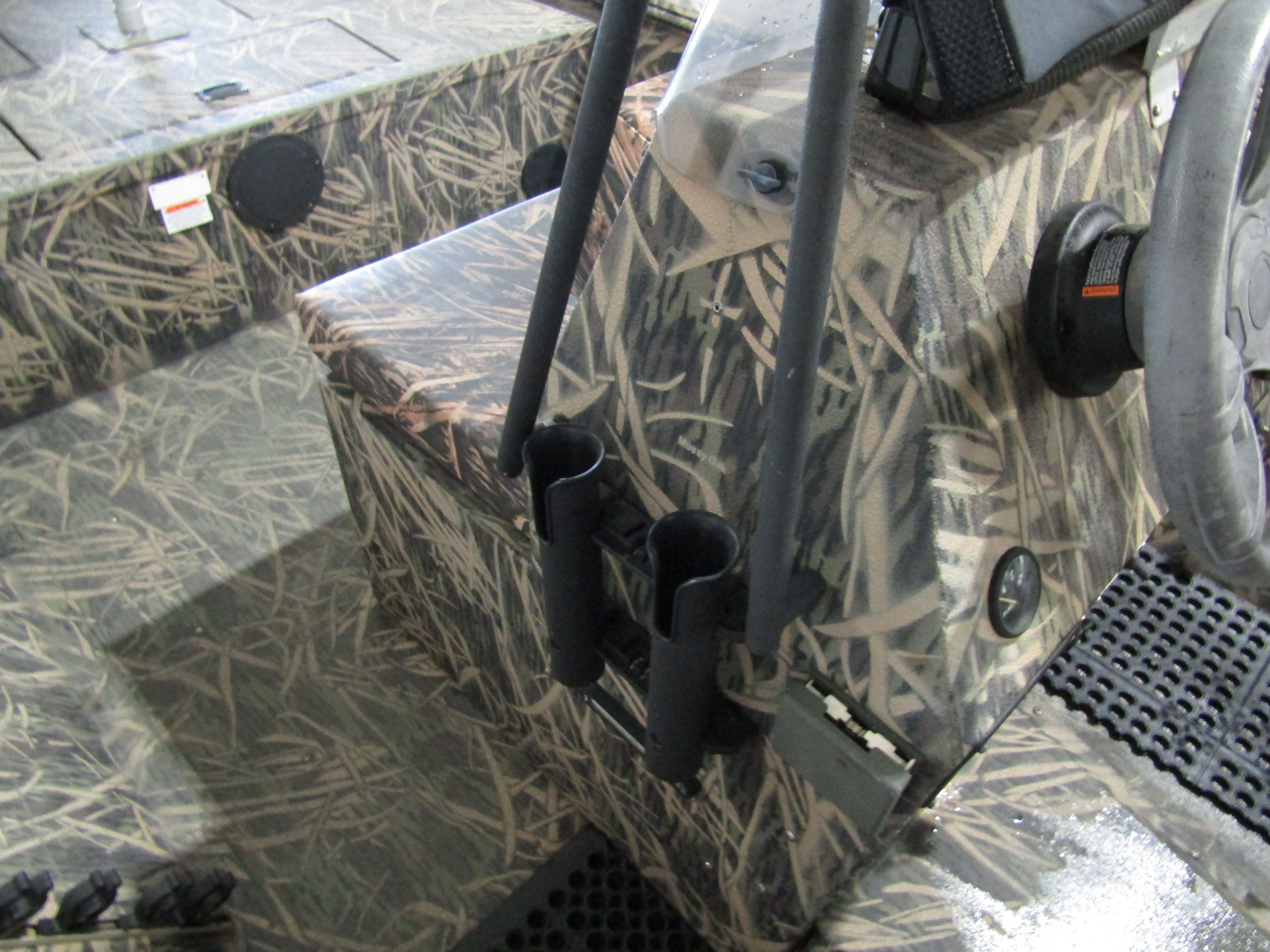 Close-up of a boat interior with camouflage pattern and rod holders.