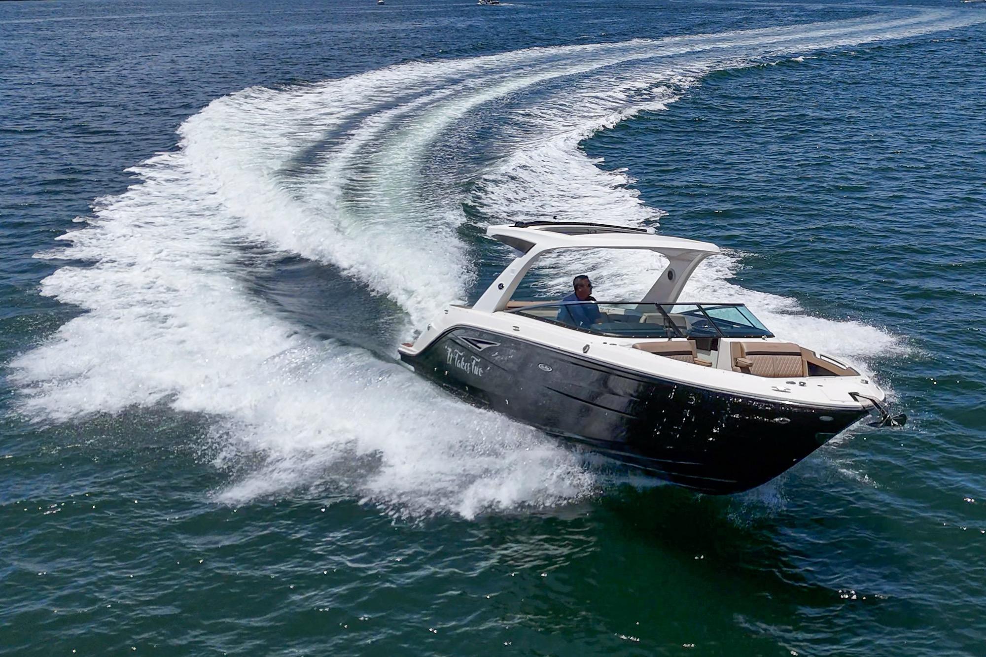 2018 Sea Ray SLX 310 cruising on open water, creating a dynamic wake.