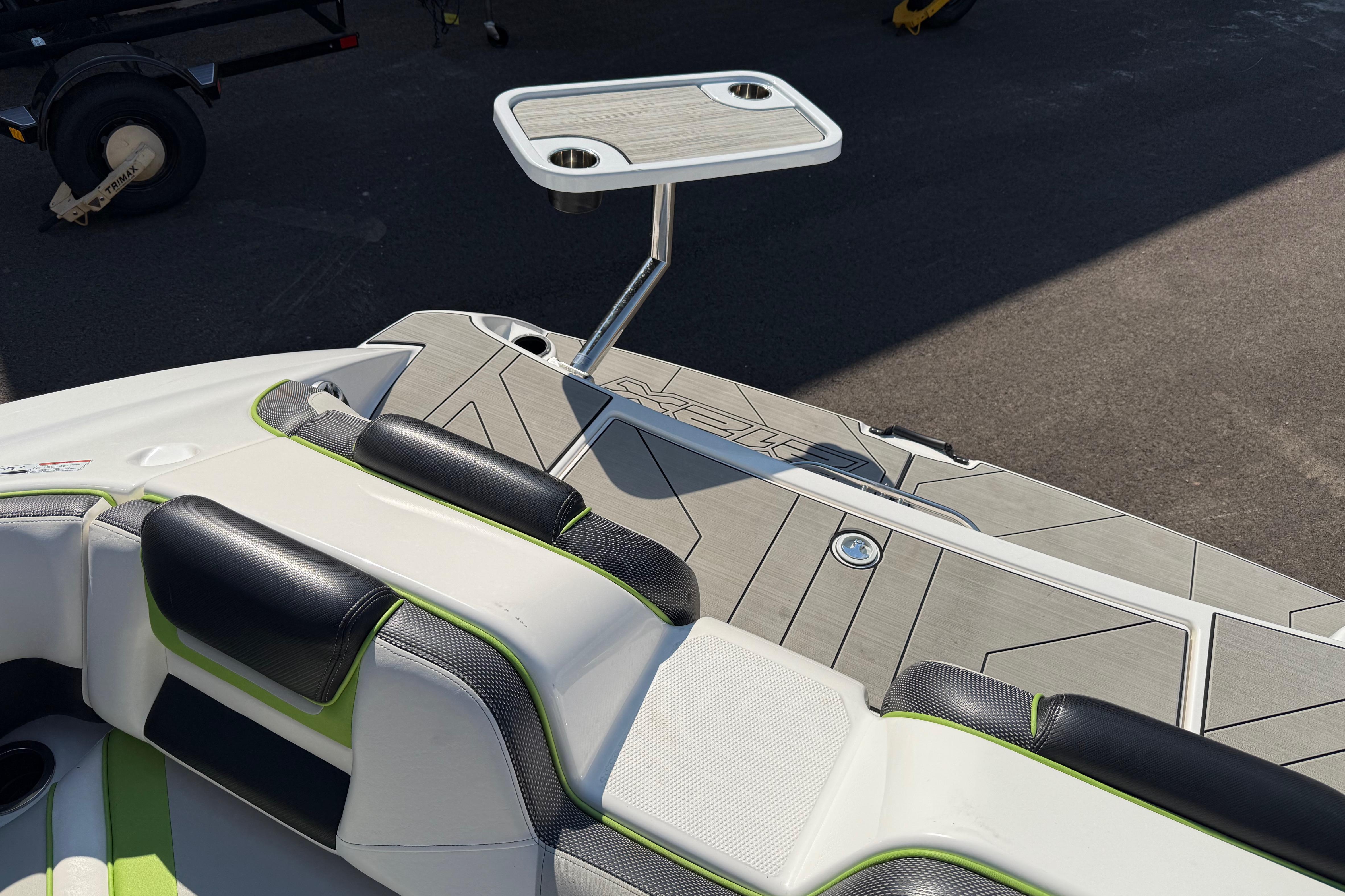 2022 Yamaha Boats 212XE interior with seating and a mounted table on deck.
