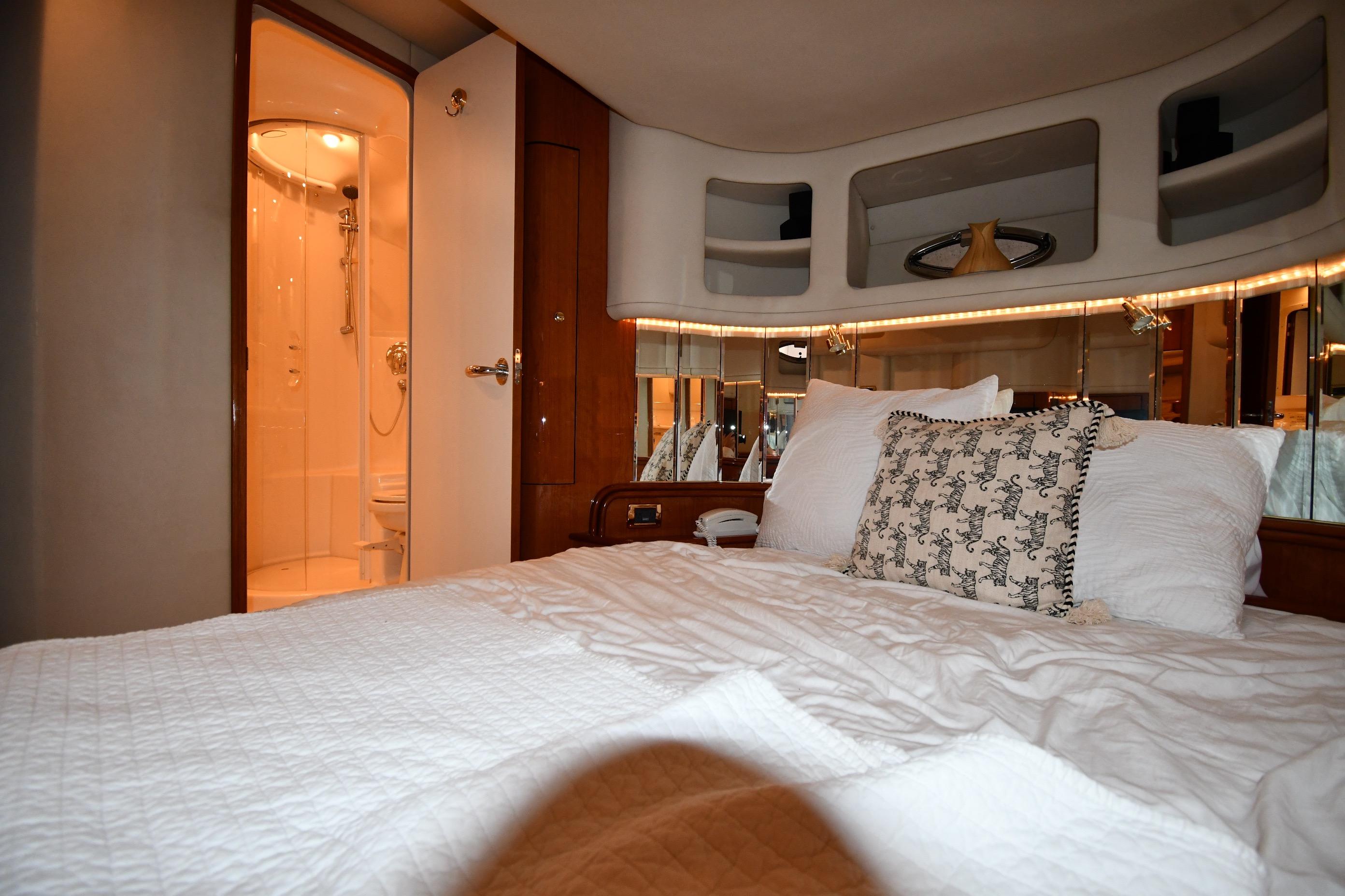 Luxurious bedroom interior of 2001 Sea Ray 540 Sundancer yacht with ensuite bathroom.