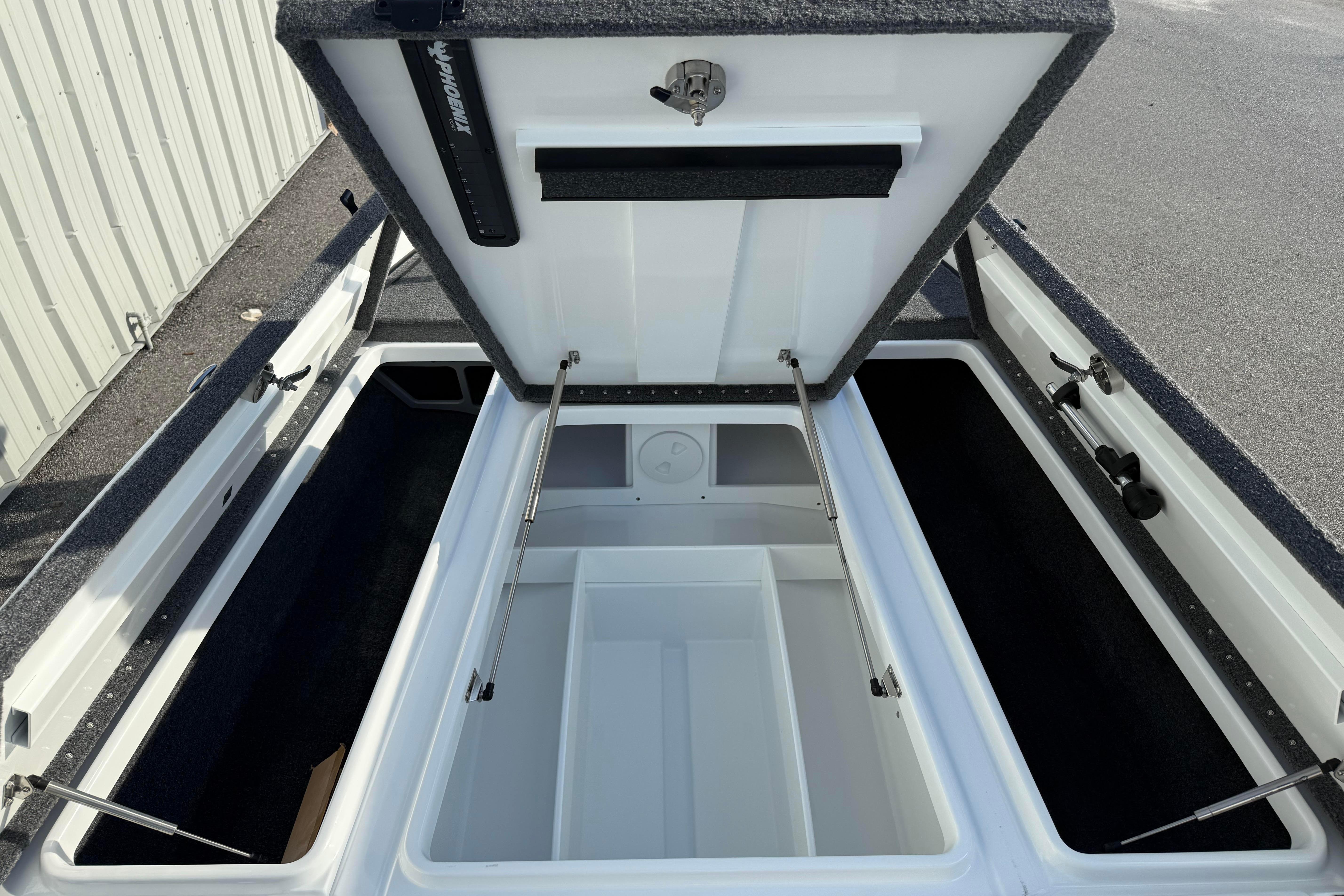 Open storage compartments of a 2027 Phoenix 721 ZXL boat, showcasing spacious interior design.
