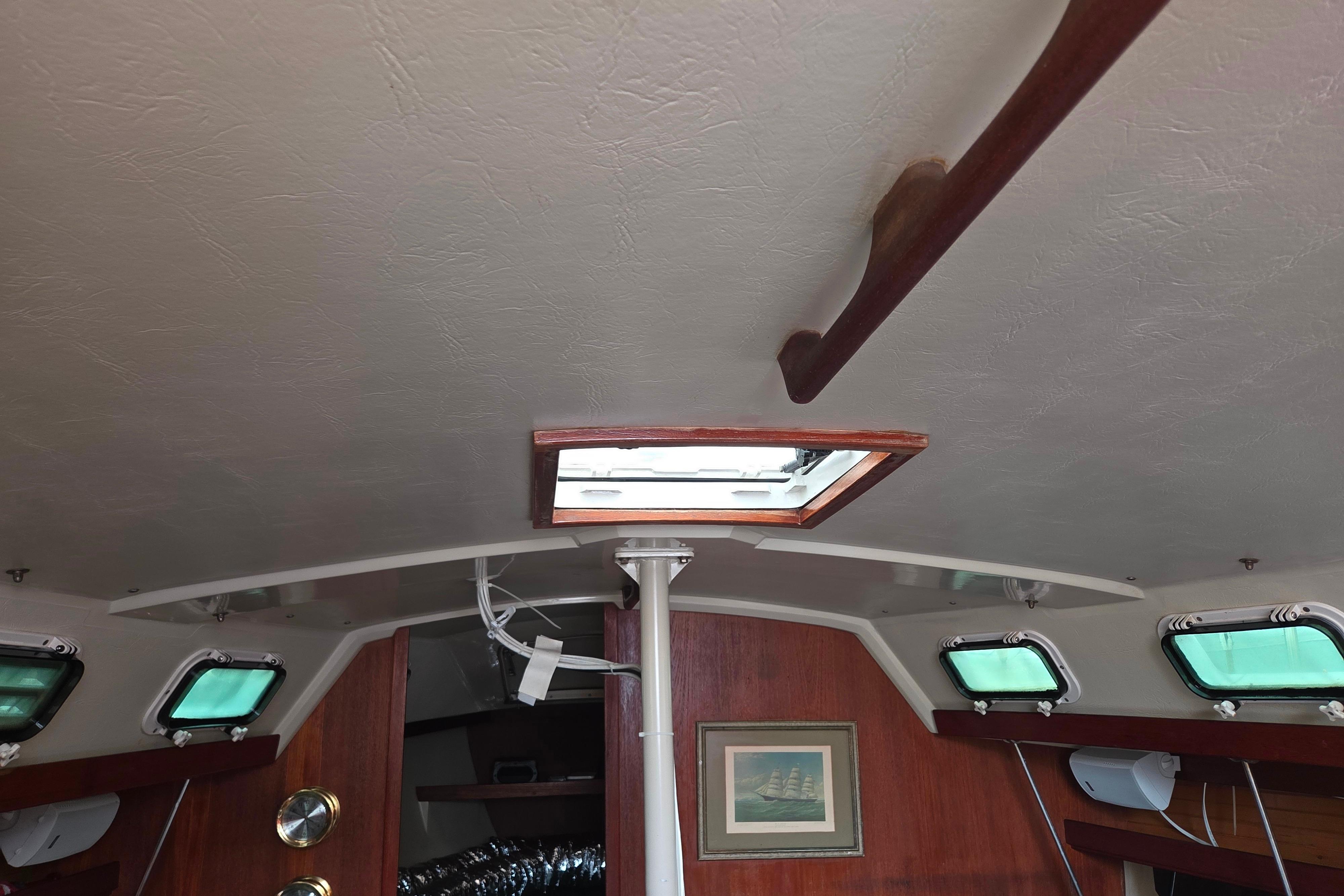 Interior of a 1986 Catalina 355 sailboat with wooden accents and a ceiling hatch.