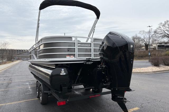 2025 Ranger Reata 243C pontoon boat with outboard motor on a trailer.