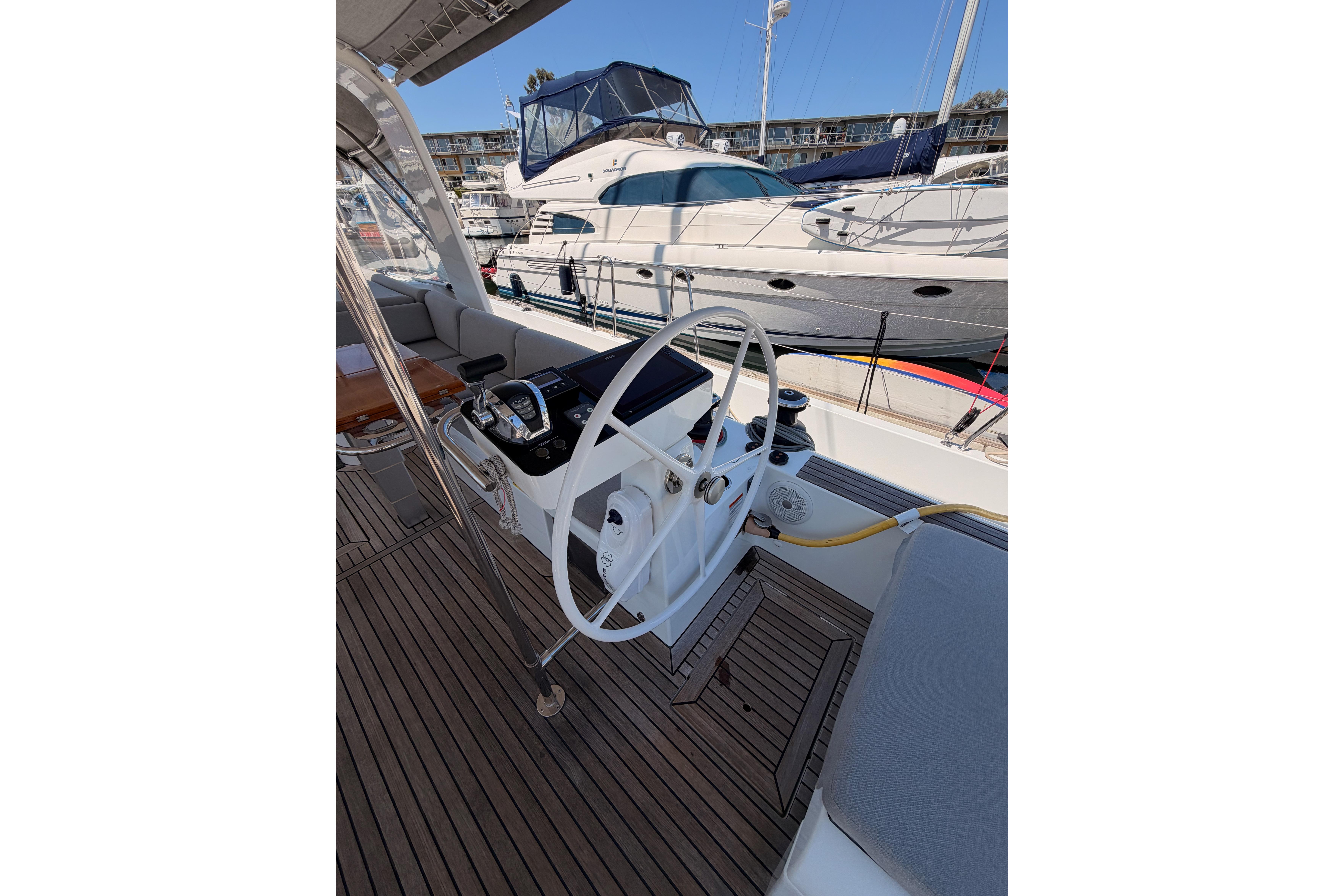 Cockpit of 2022 Beneteau Oceanis Yacht 54 with steering wheel and navigation controls.