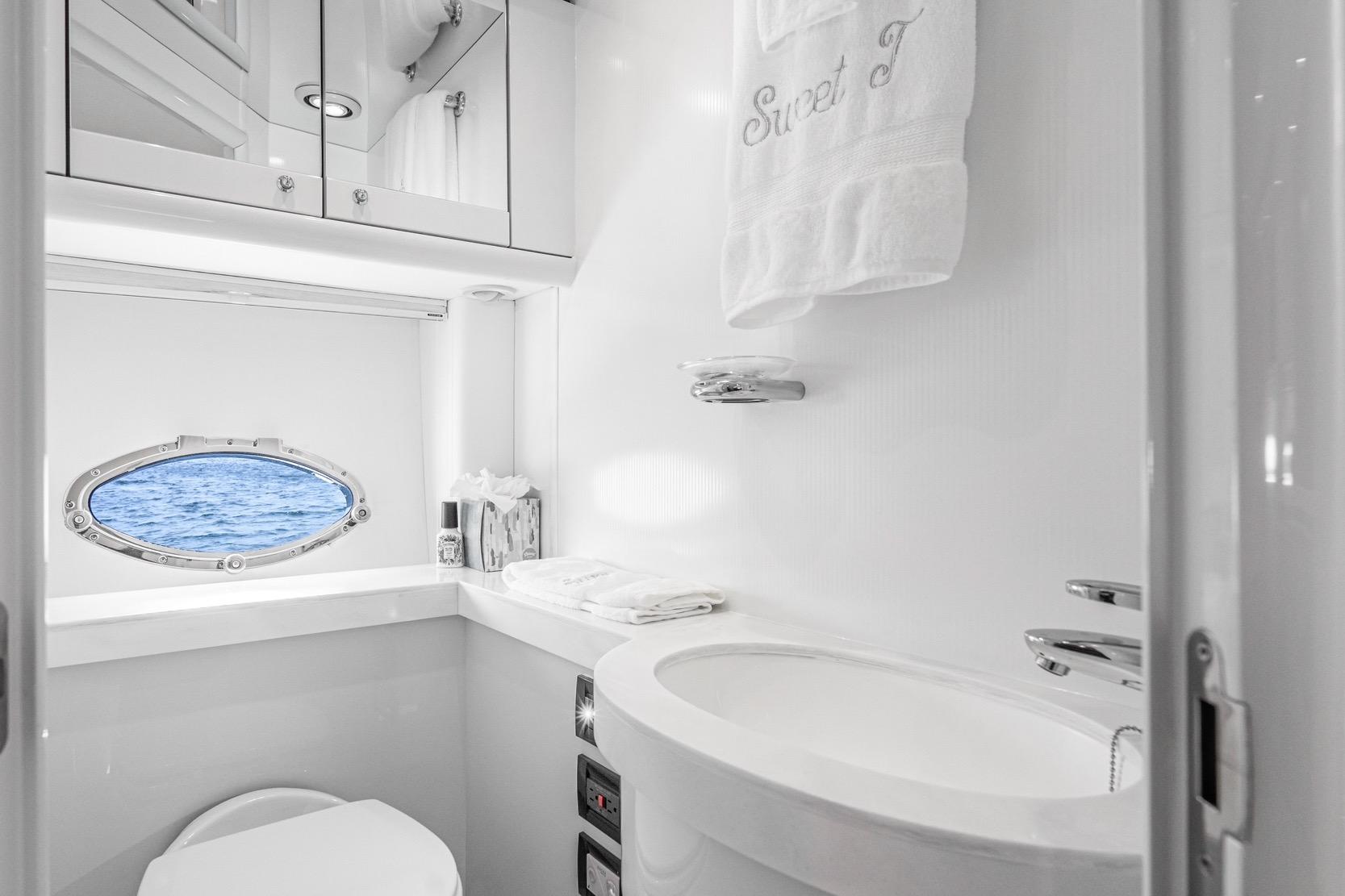 Luxurious bathroom in 2021 Sunseeker Predator 68 yacht with ocean view porthole.
