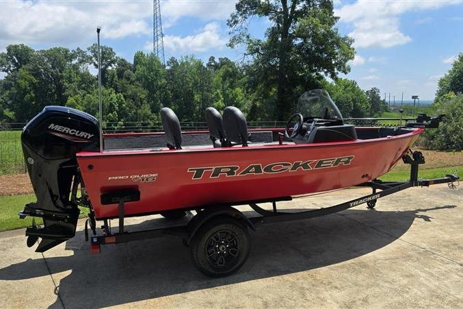 Red 2026 Tracker Pro Guide V-16 SC boat on trailer, with Mercury outboard motor.