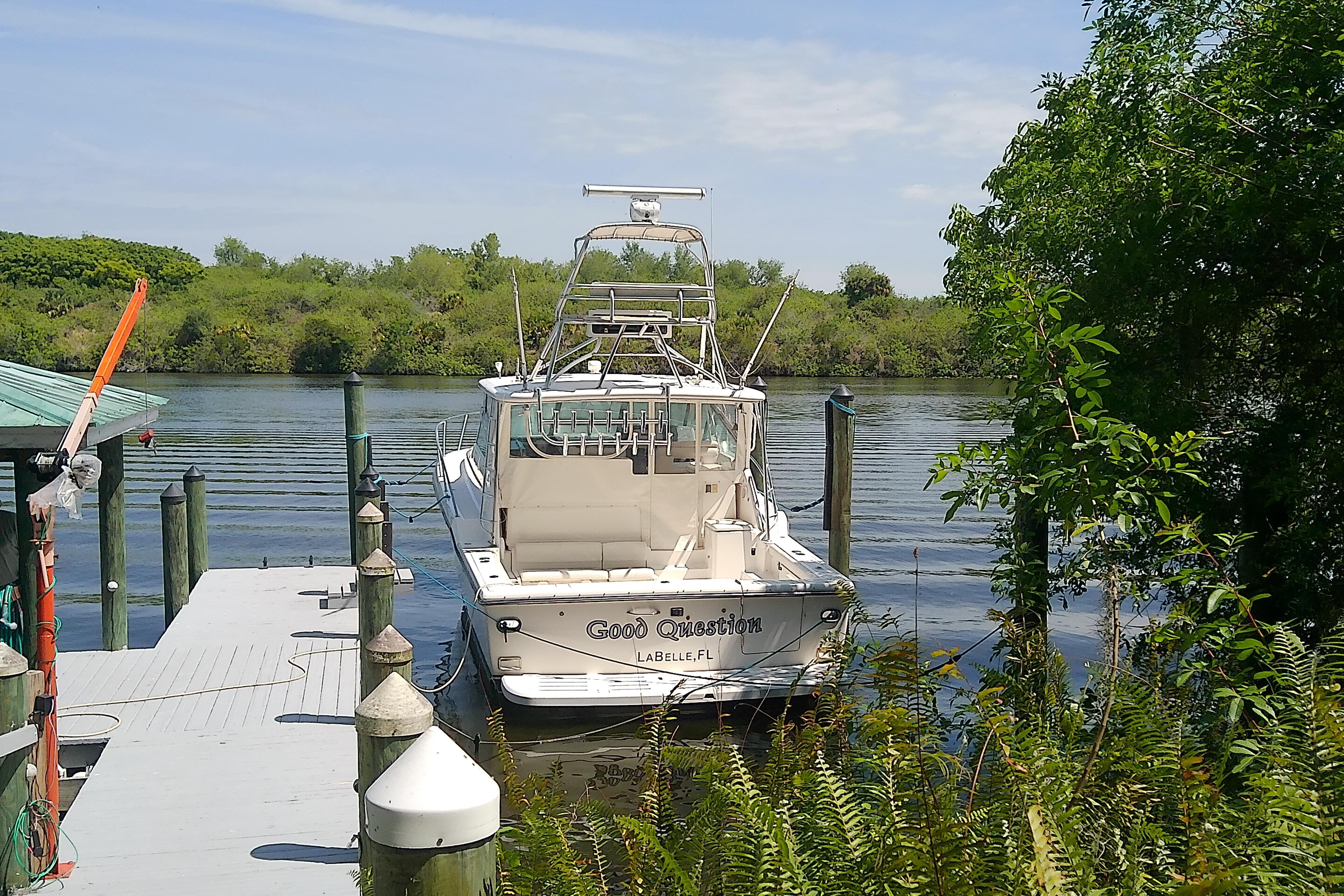 2000 Tiara Yachts 4100 Open docked by lush greenery and calm waters.
