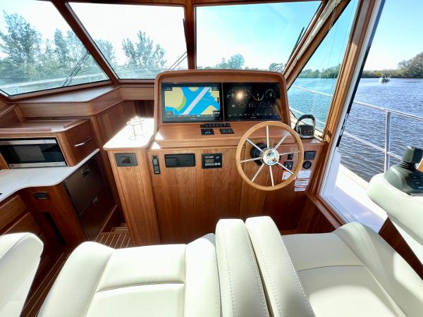 2025 Sabre 43 Salon Express helm with navigation screens and wooden steering wheel.