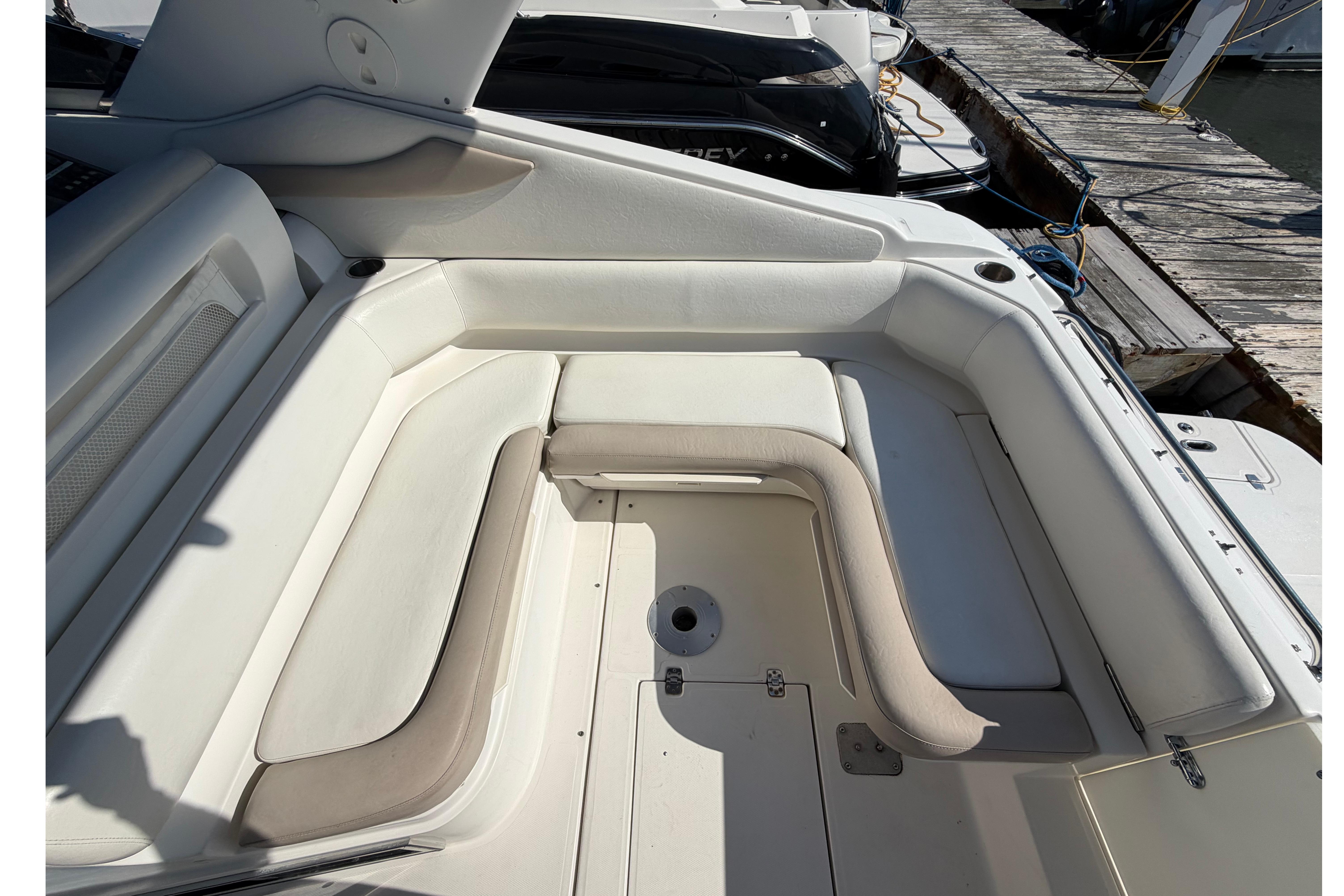 2003 Regal Commodore 3260 boat interior with white cushioned seating and dock view.