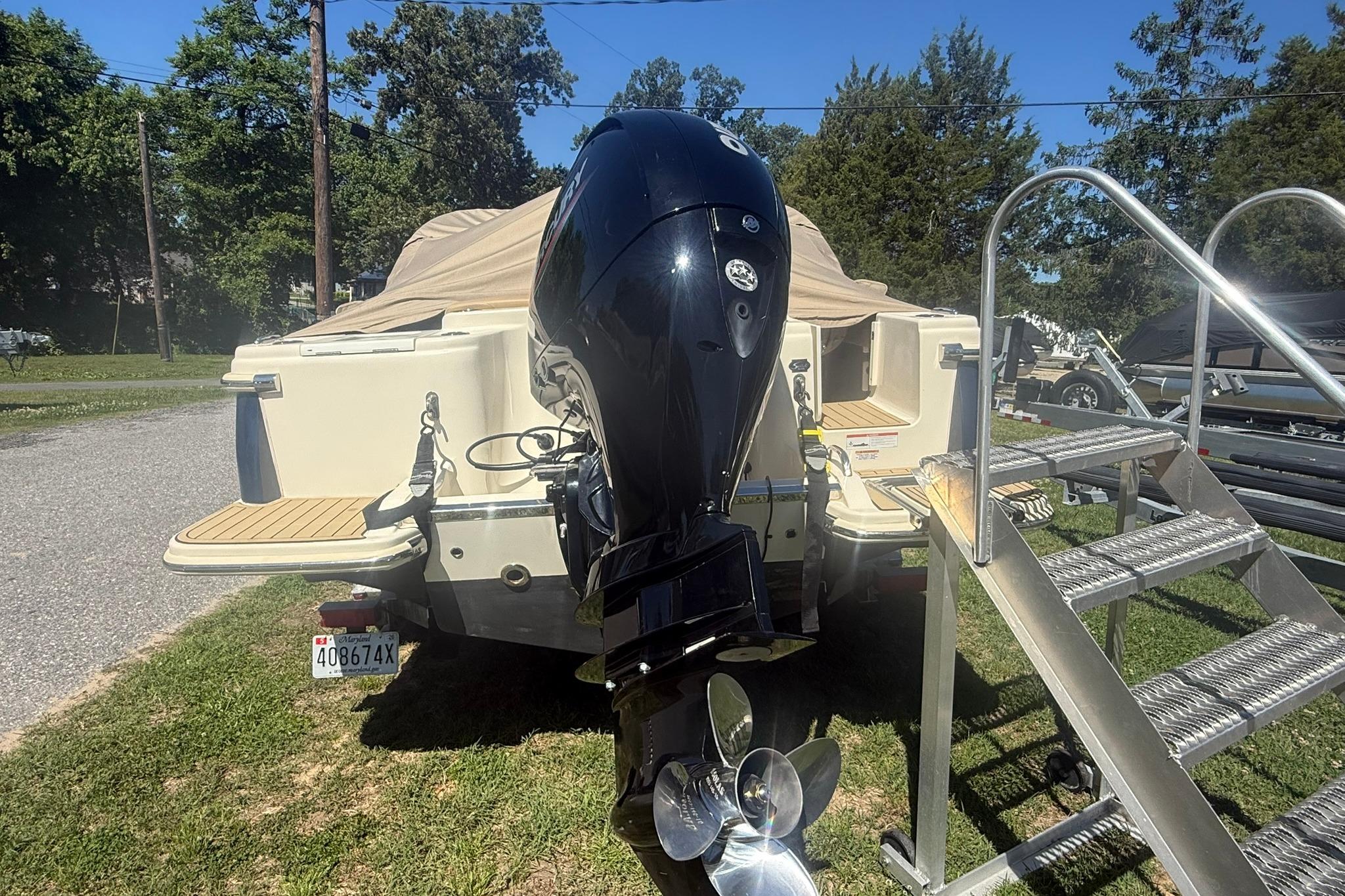 2021 Scout 215 Dorado boat with outboard motor and covered deck.