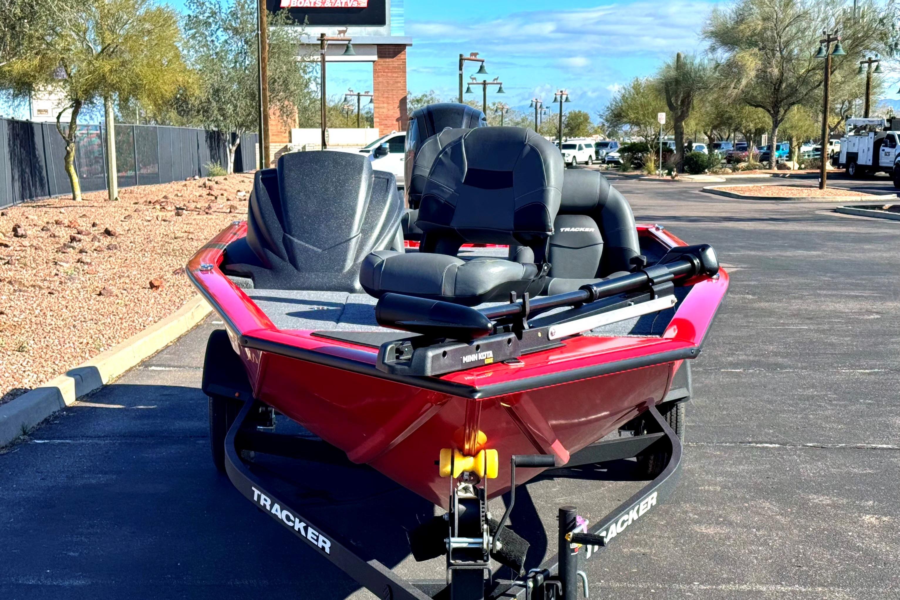 2026 Tracker Pro Team 175 boat in parking lot, featuring sleek red design and comfortable seating.