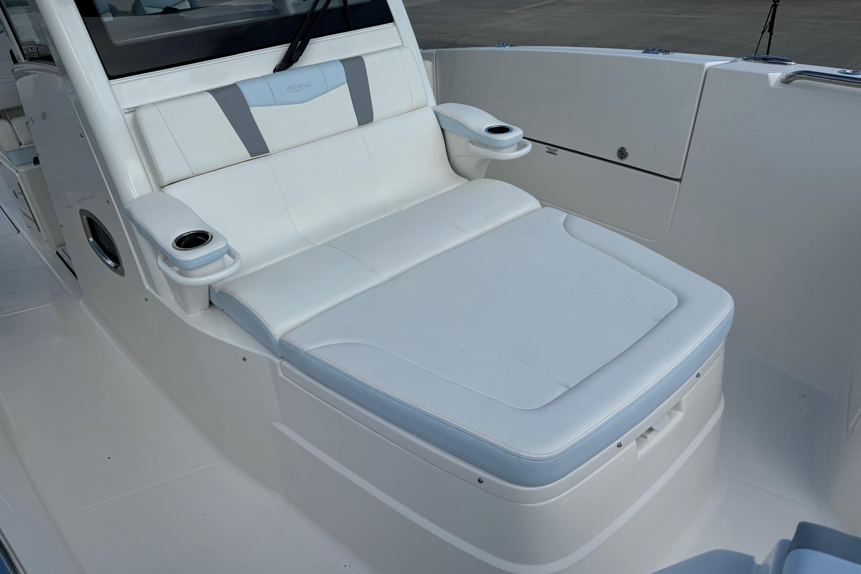 2025 Robalo R360 Center Console boat with white cushioned seating and cup holders.