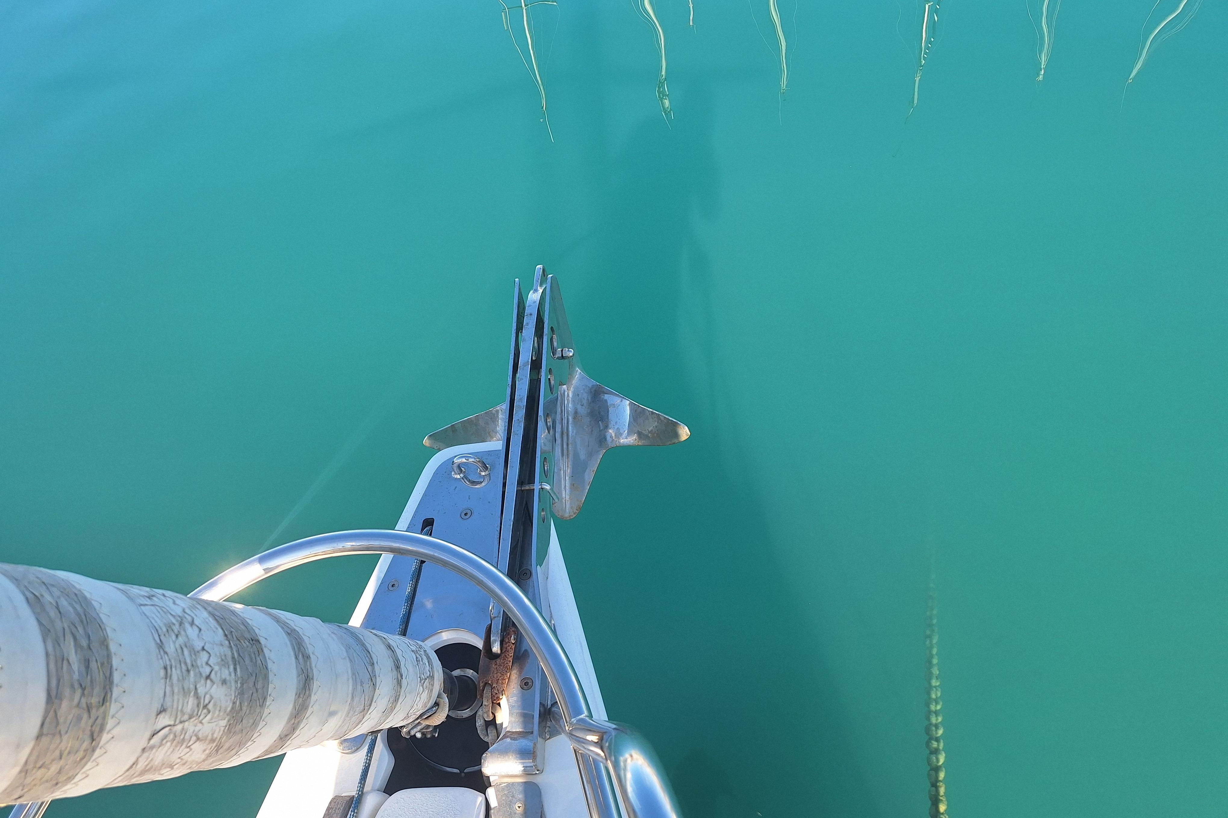 Bow of 2006 X-Yachts X-43 sailboat with anchor over turquoise water.