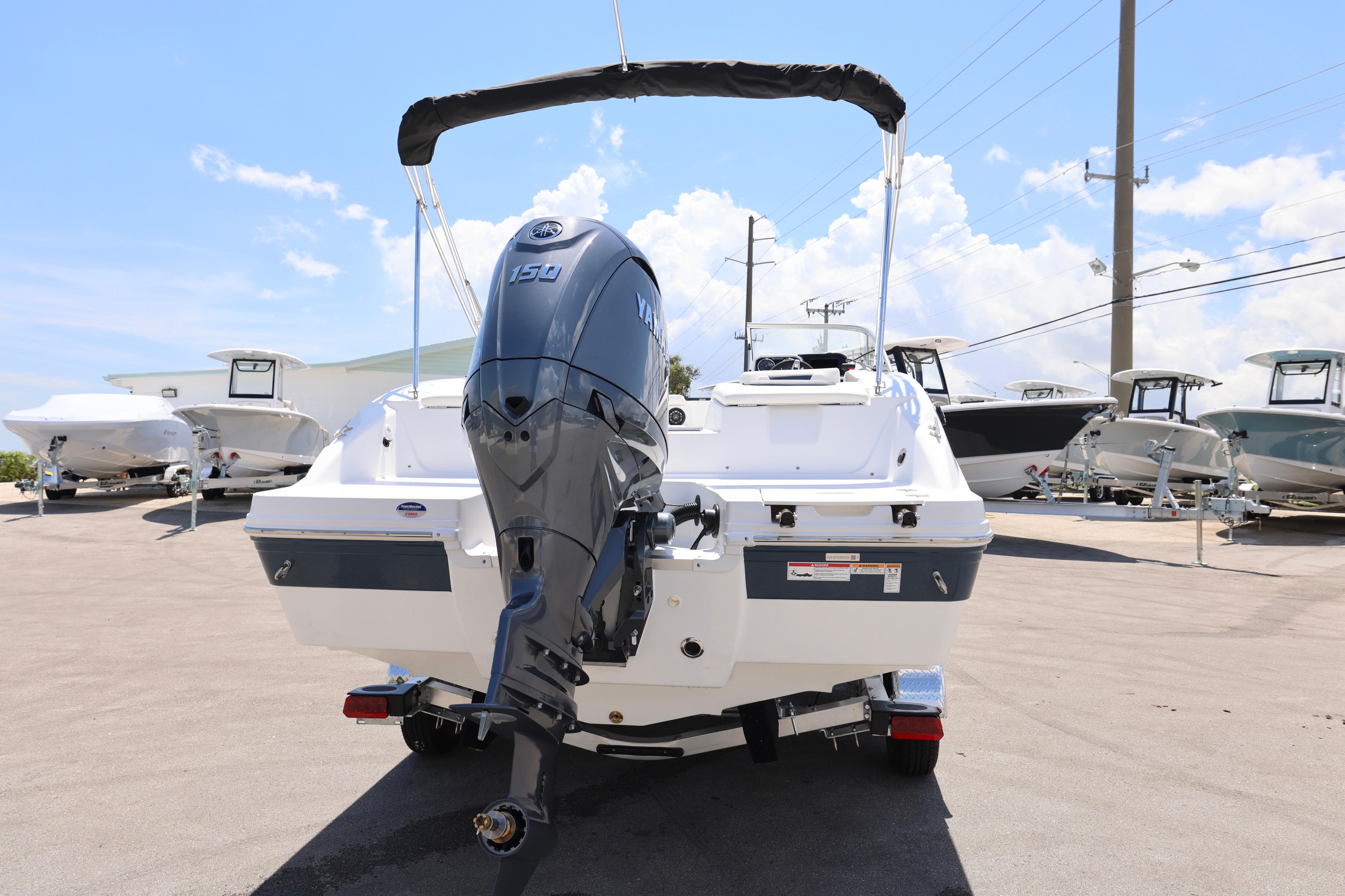 2026 Hurricane SunDeck 2050 OB boat with Yamaha 150 engine, parked outdoors.