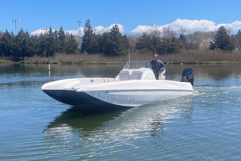 2025 Hustler 25 C3 Speedfish boat cruising on a calm lake.
