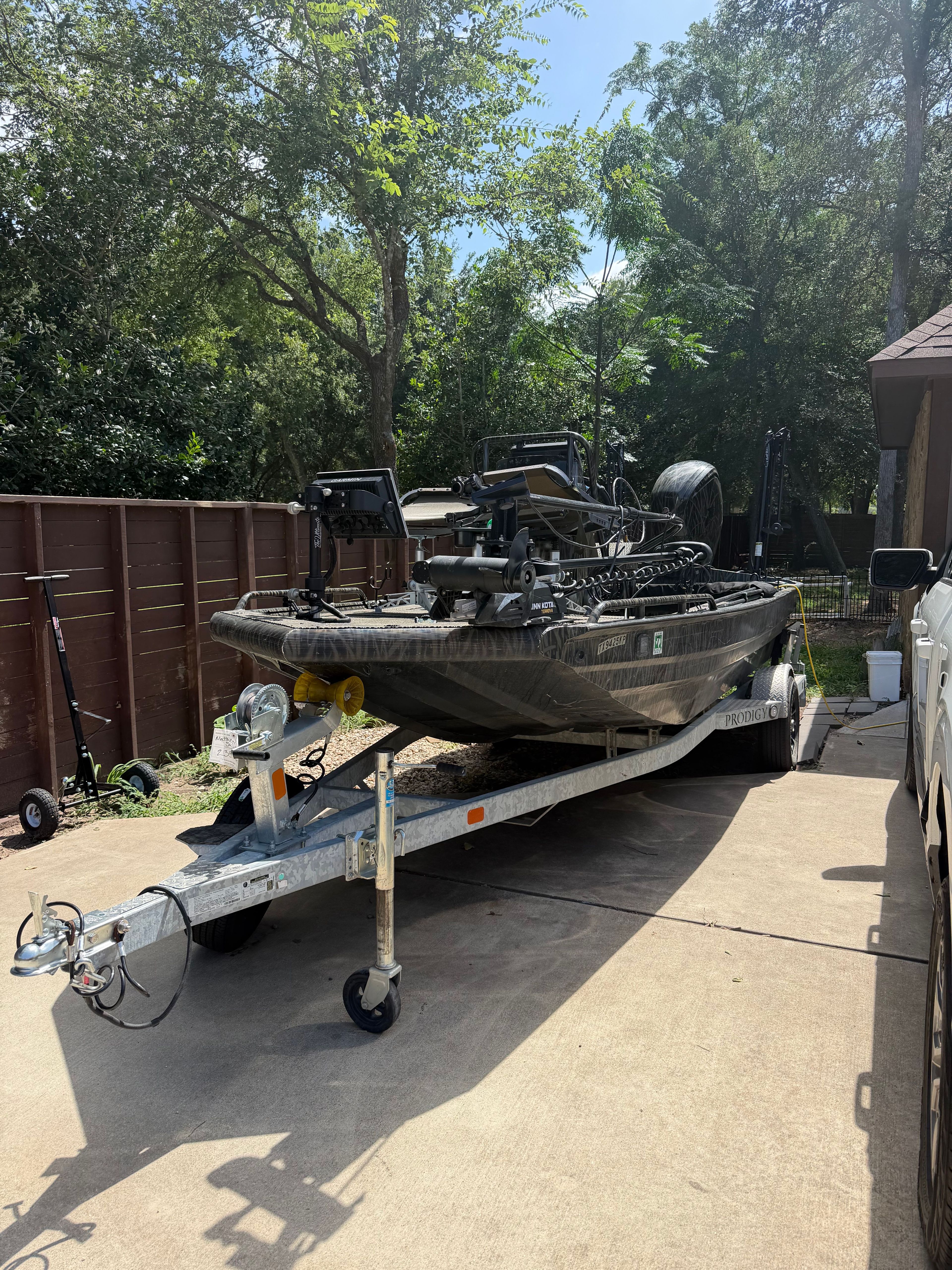 A 2023 Prodigy 1860 boat on a trailer in a driveway.