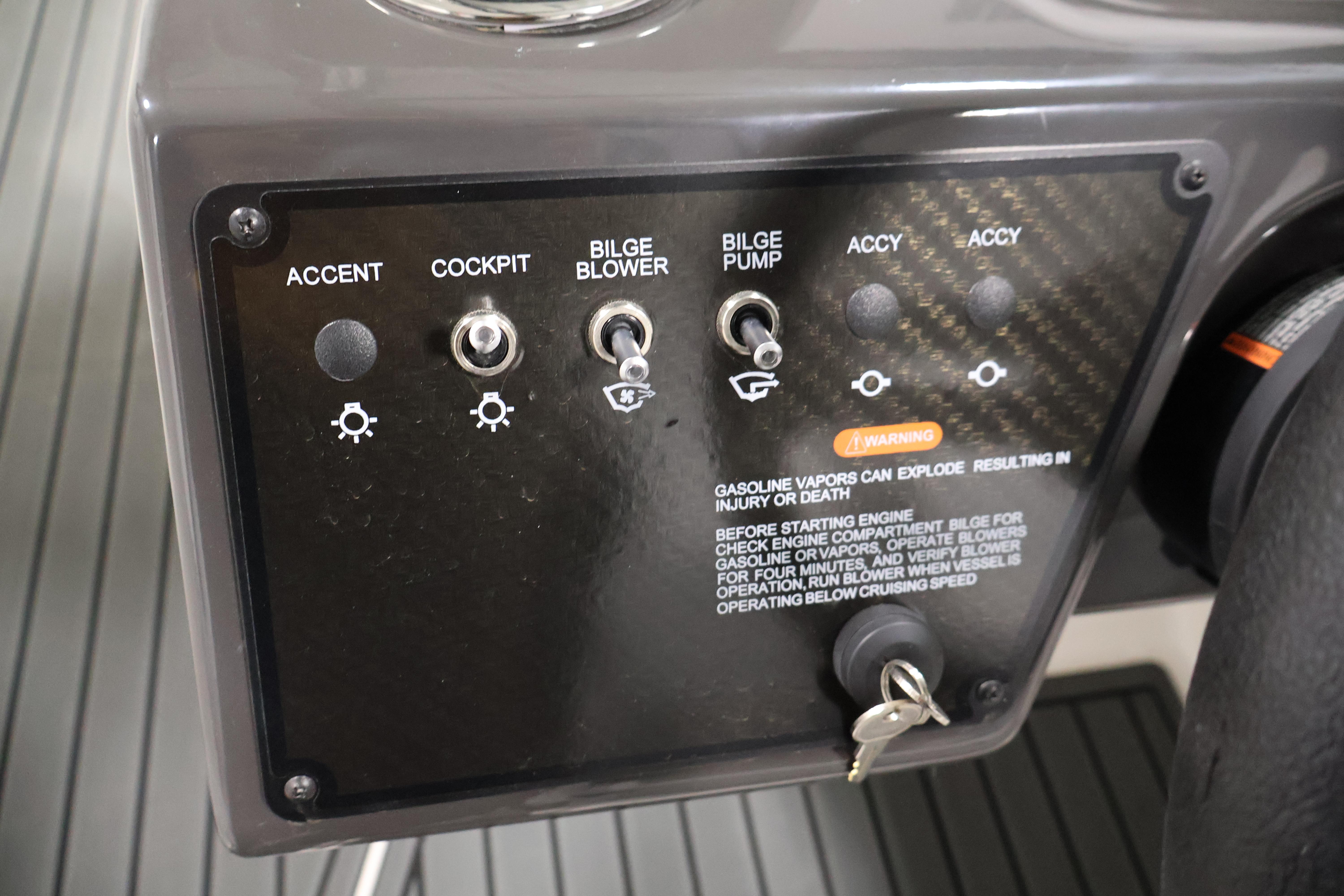 Control panel of 2026 Bayliner VR6 Bowrider I/O with switches and warning label.