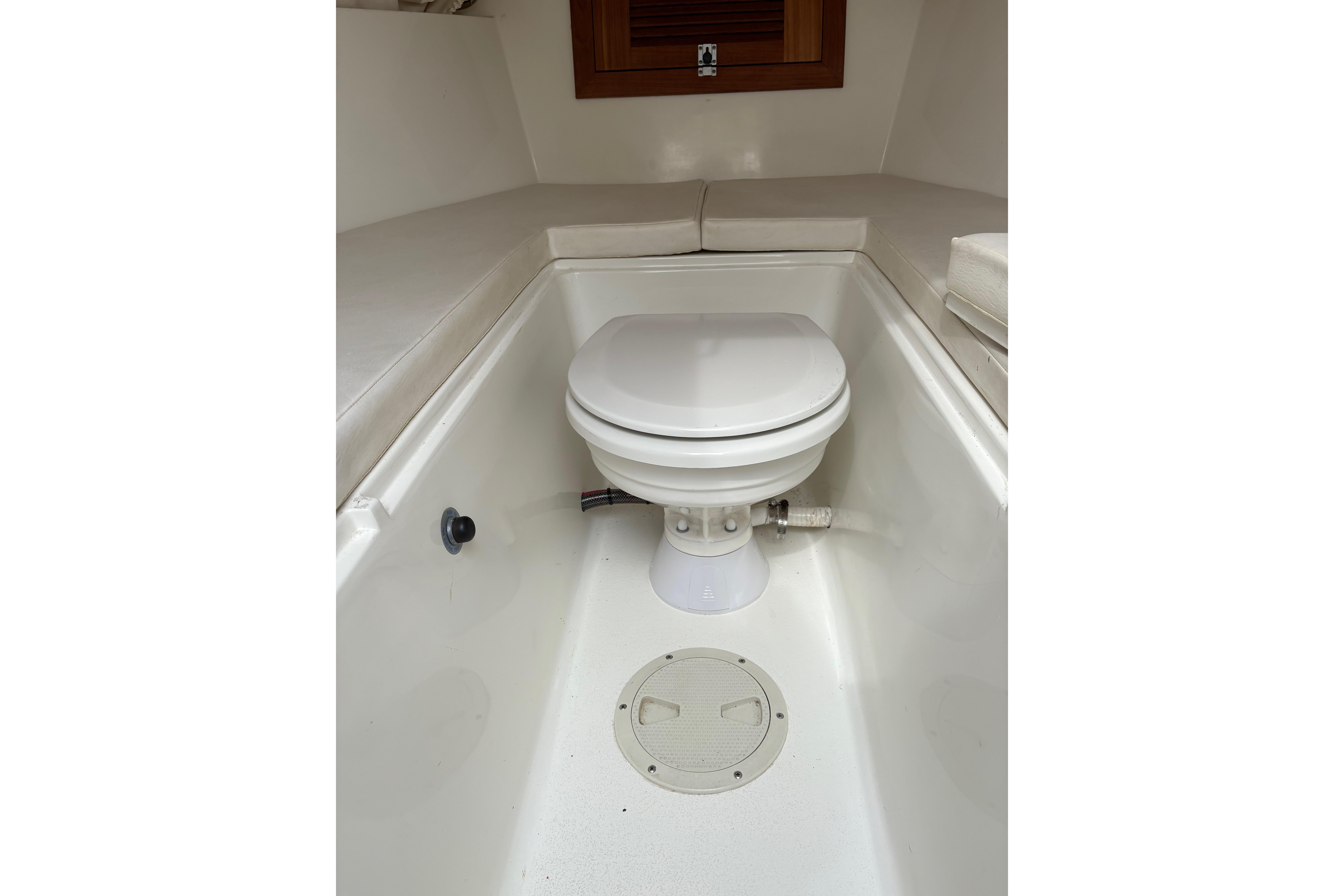 1994 Intrepid 30 Open Cuddy boat interior with a compact marine toilet.