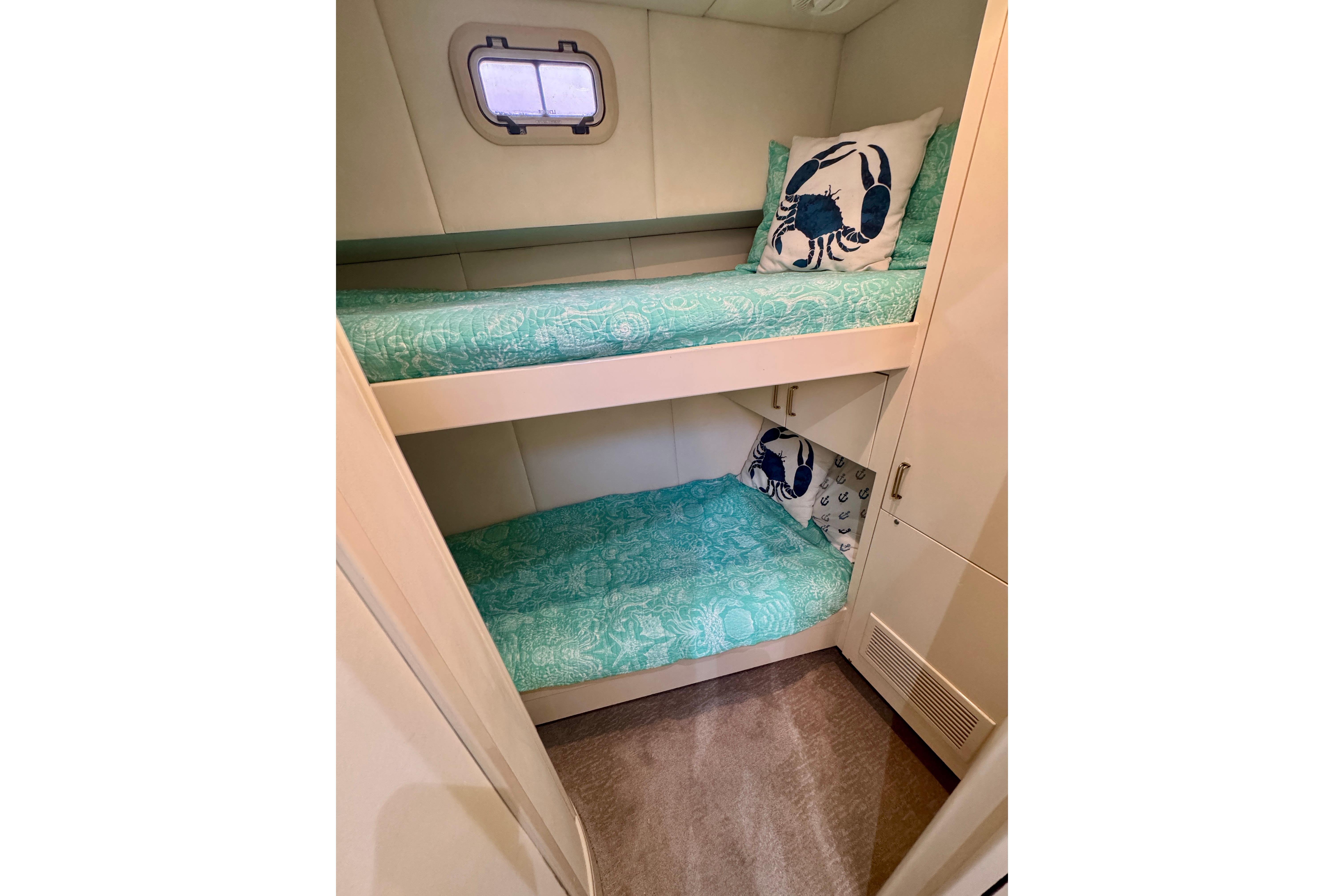 Bunk beds with teal bedding in 1995 Queenship 62 Pilothouse Motor Yacht cabin.