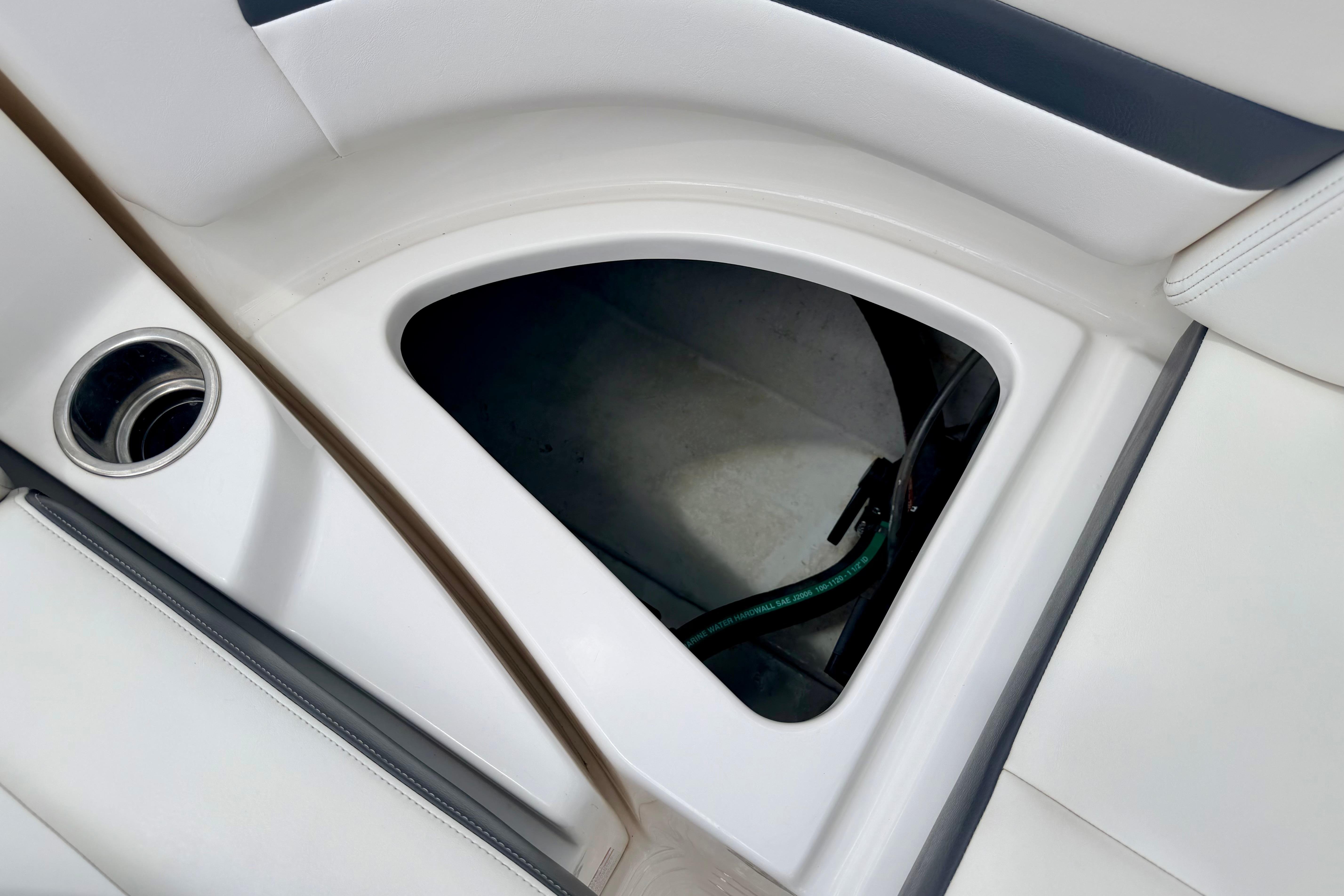 Storage compartment in 2015 Chaparral Sunesta 264 boat, featuring sleek white interior design.