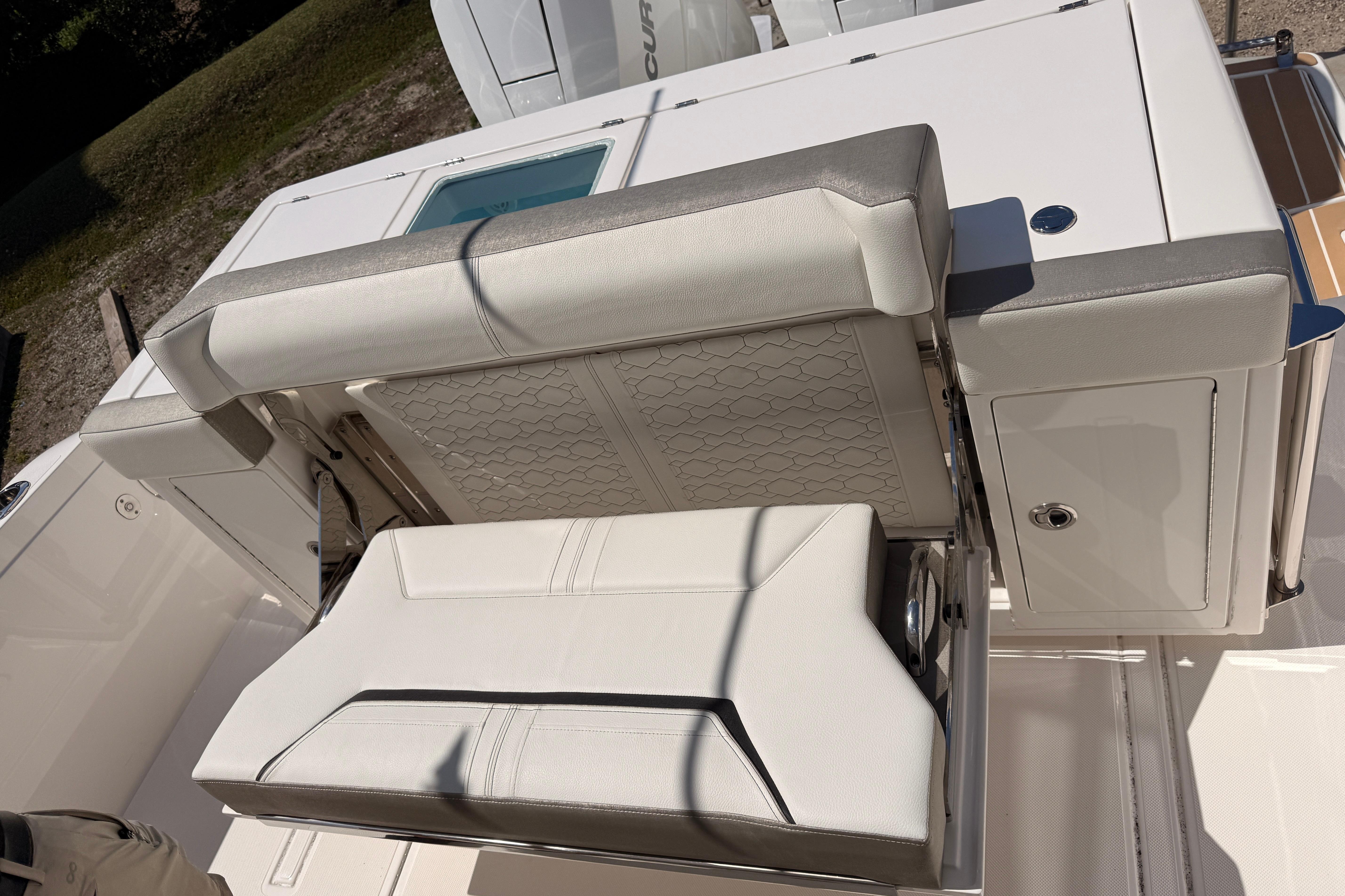 2024 Tiara Yachts 34 LS boat seating area with white upholstery and storage compartment.