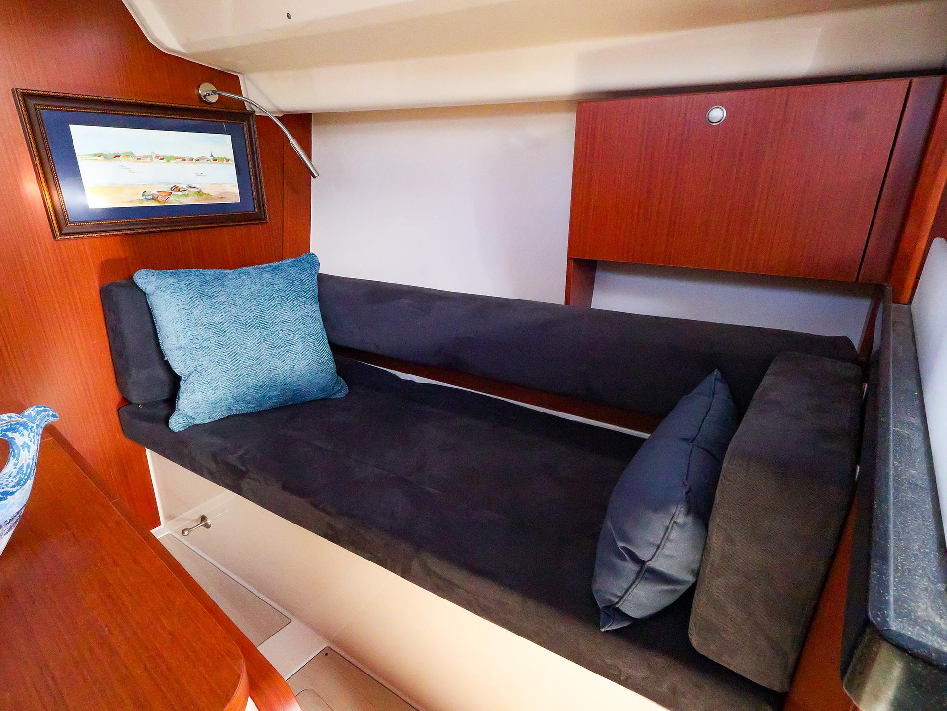 Cozy interior of 2018 Hanse 315 yacht with cushioned seating and decorative pillows.
