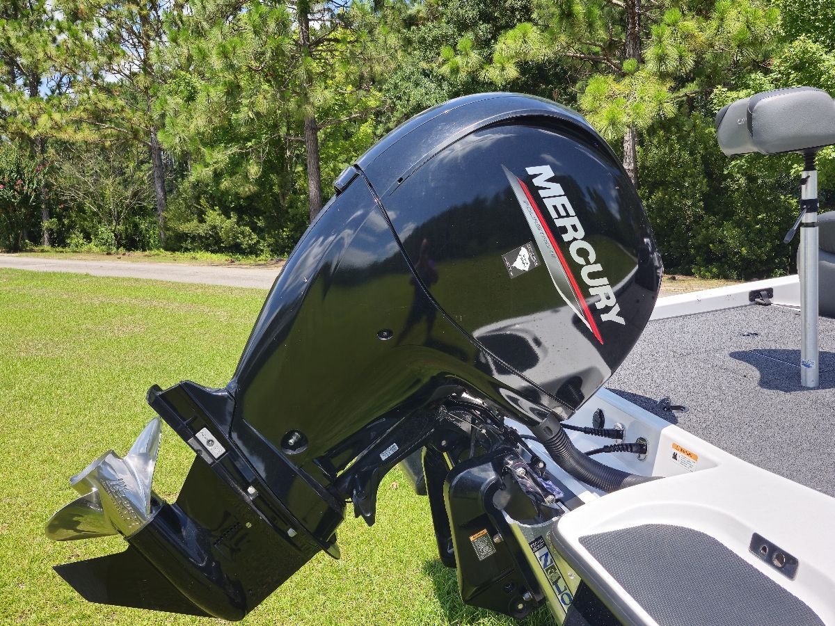 A Mercury outboard motor on a 2021 Caymas CX 18 SS boat, parked on grass.