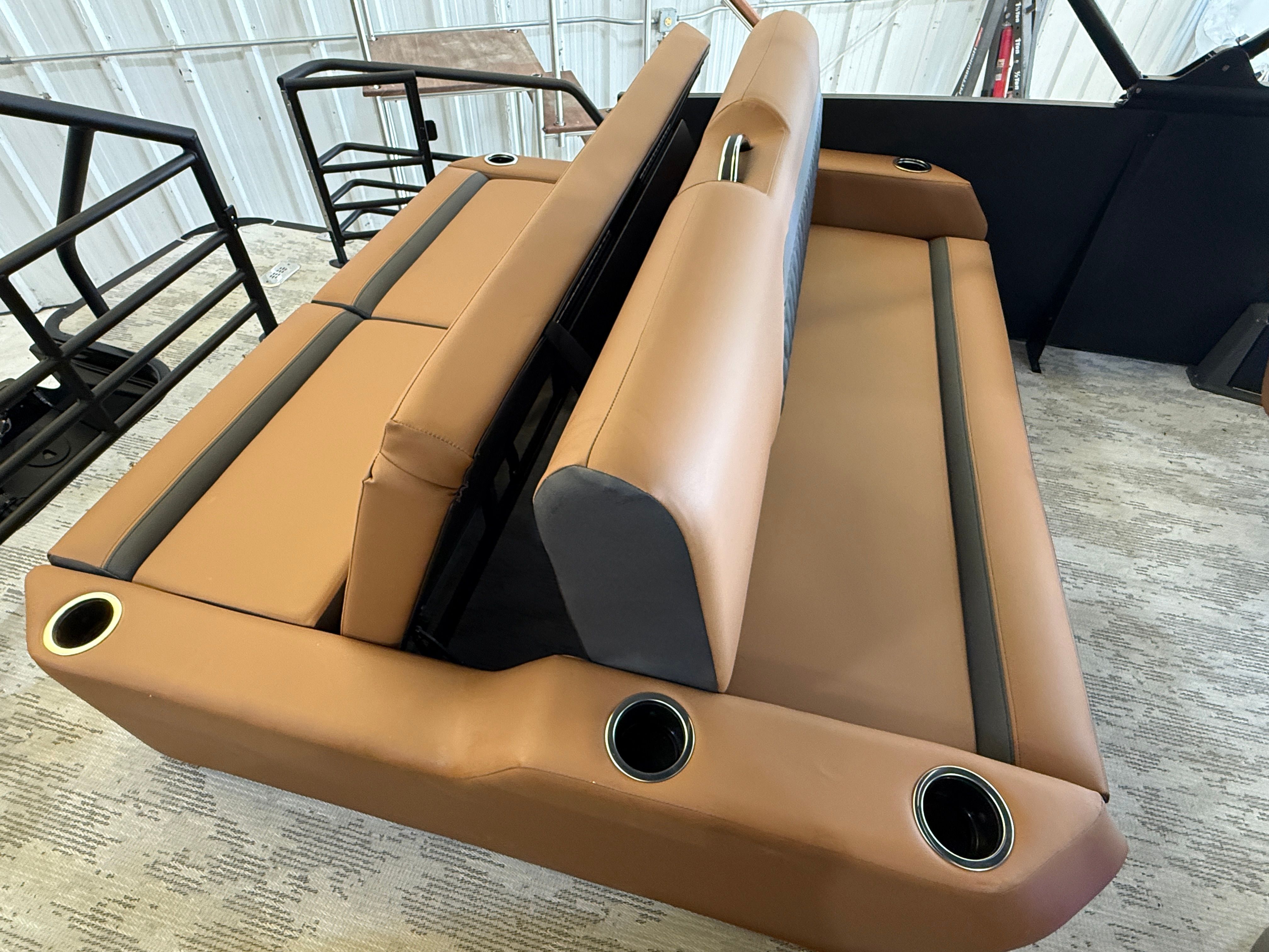 The interior of the 2026 Sylvan L3 ULZ DH features luxurious brown upholstery with cup holders.